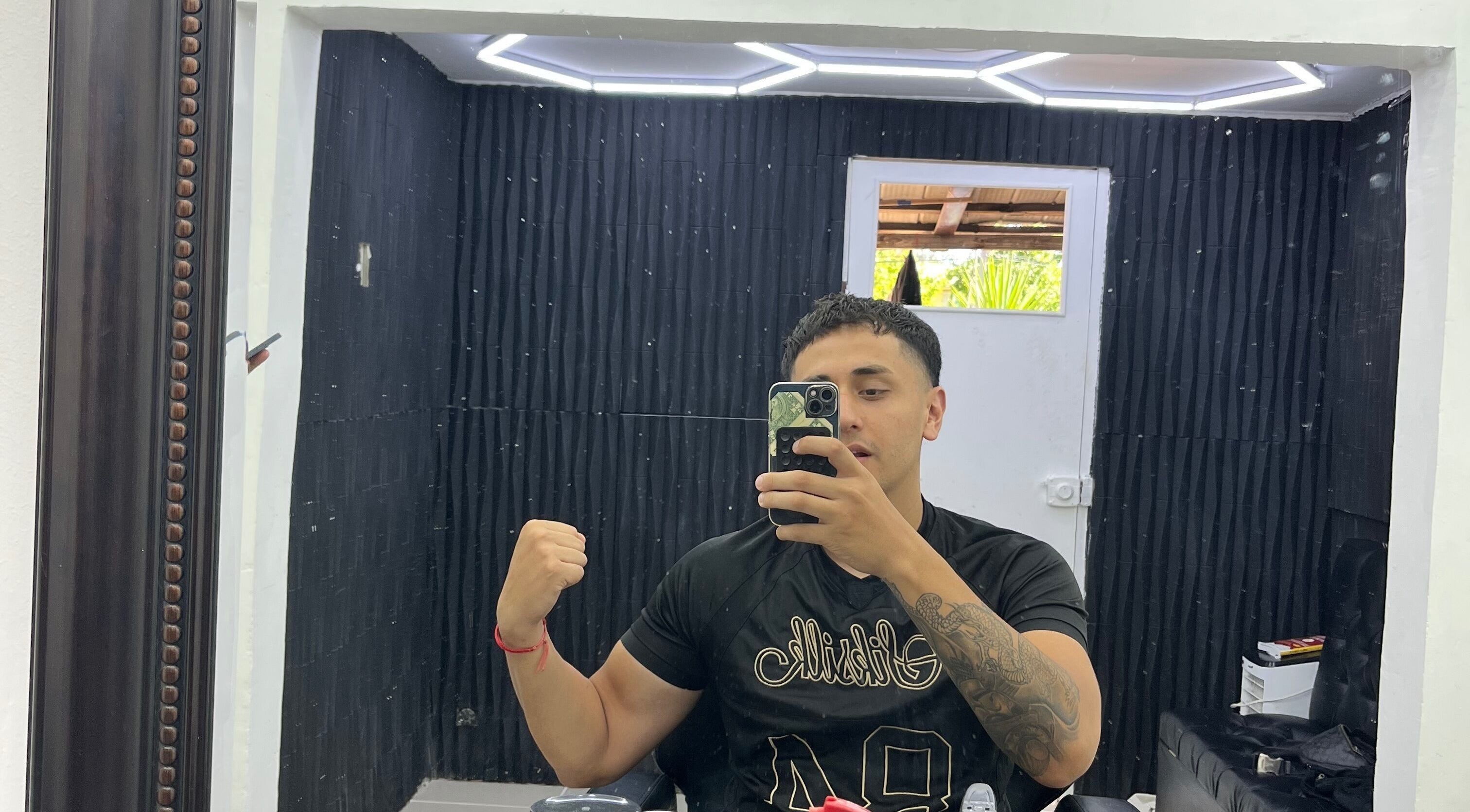 Interior de Drako Barber Studio, La Florida, Región Metropolitana, CL, con cliente frente al espejo.