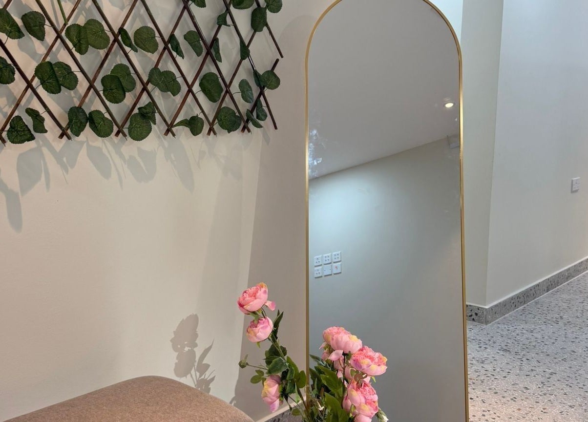 Chic interior of Remal Beauty Salon in Zinj, Muḥāfaẓat Al-ʿāṣimah with mirror and floral decor.