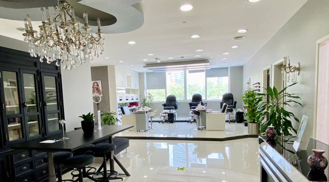 Elegant interior of The Hair Alchemist in Dubai, Dubai, AE showcasing stylish furniture and a chandelier.