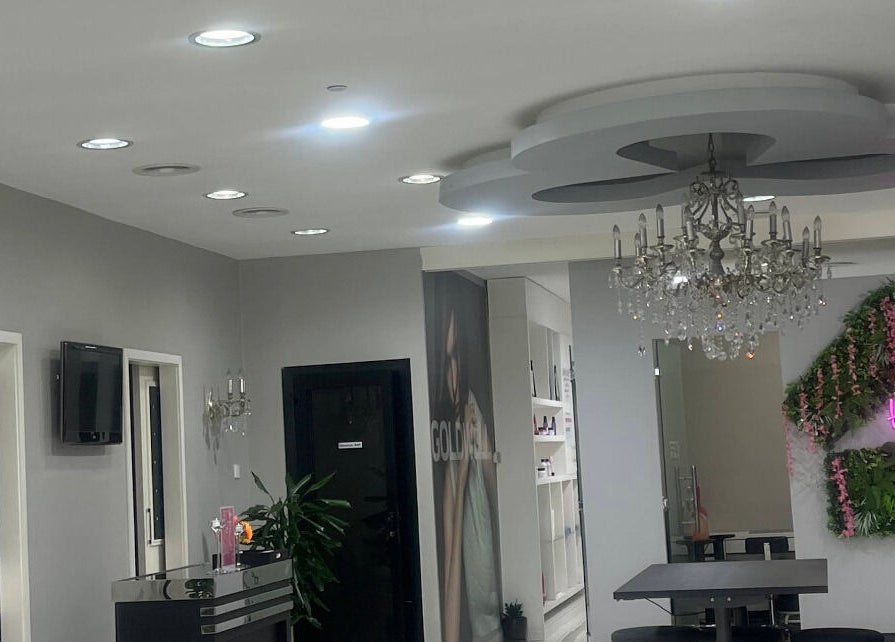 Chic interior of The Hair Alchemist in Dubai, Dubai, AE with chandeliers and modern decor.