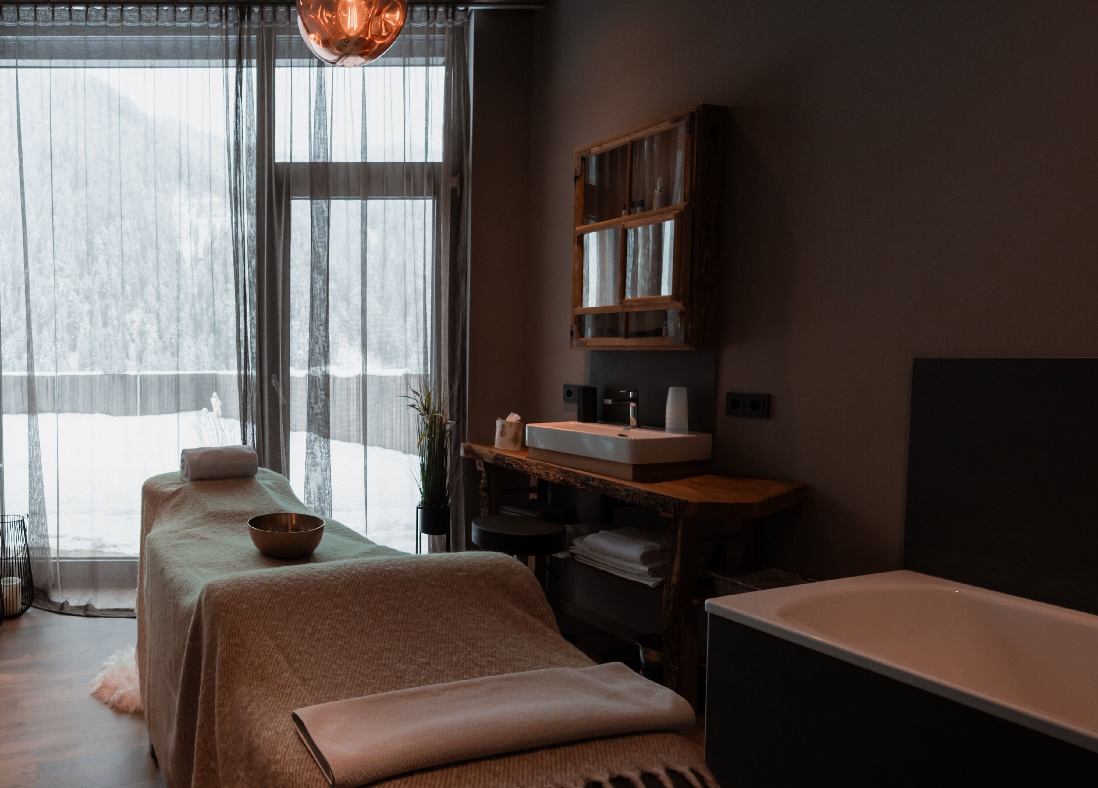 Brandgut - vor Freude glühen in Viehhofen, Salzburg, AT's elegantes Spa-Zimmer mit Massagebett und Bergblick.