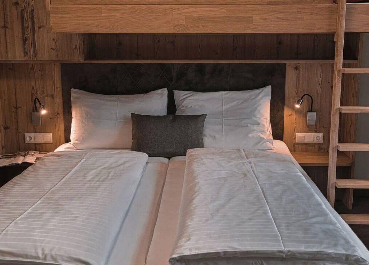 Einladendes Doppelbett im rustikalen Zimmer von Brandgut - vor Freude glühen in Viehhofen, Salzburg, AT.