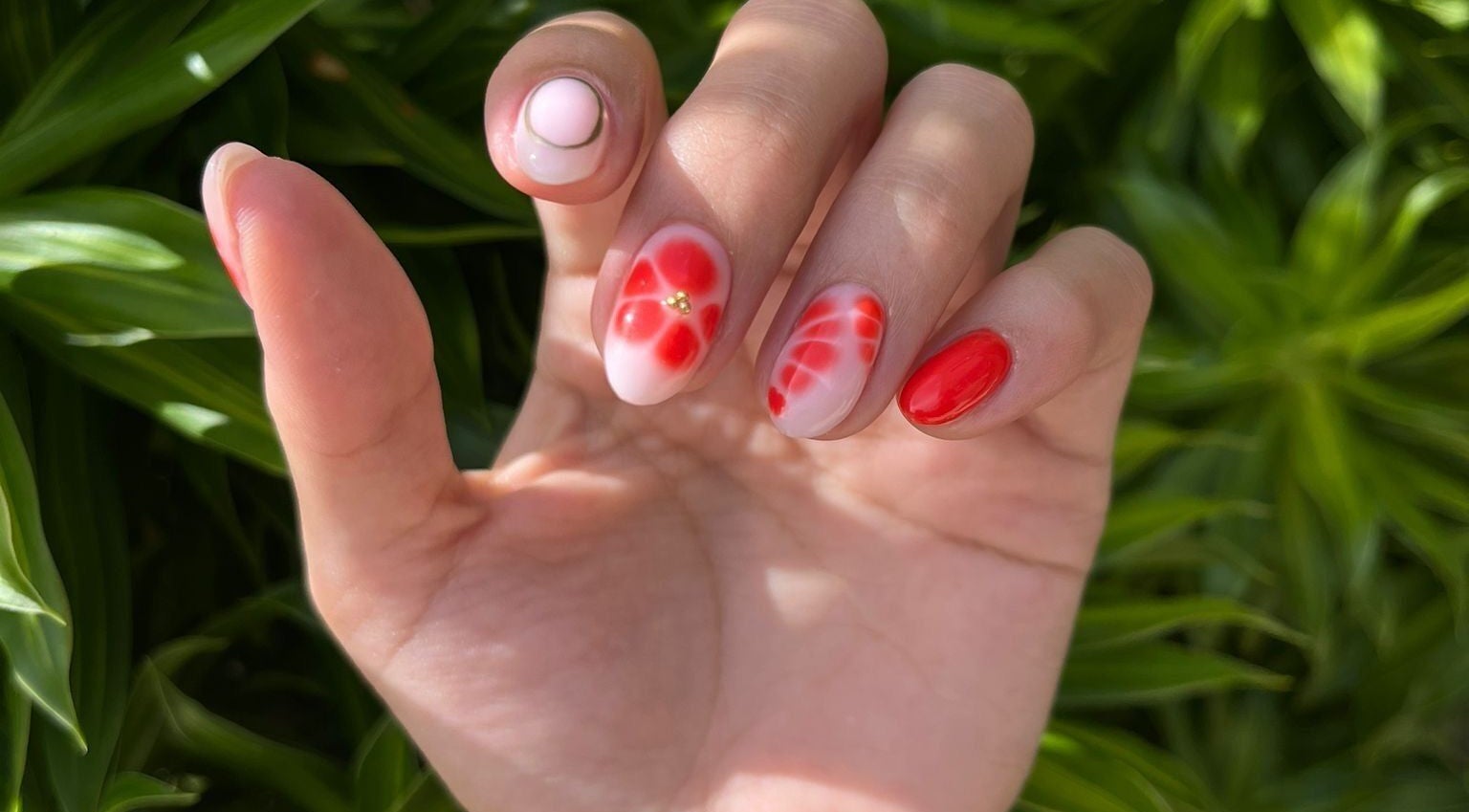 Close-up of floral nail art design at Nailz PR, Guaynabo, PR, PR, showcasing red and white petals.