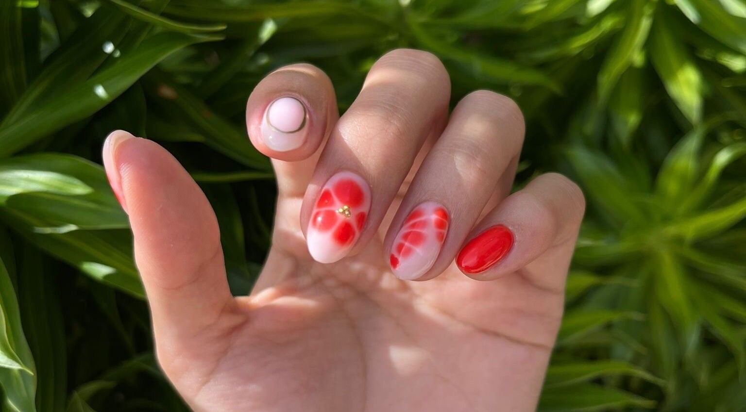 Red floral nail art design at Nailz in Guaynabo, PR. Elegant and detailed manicure.