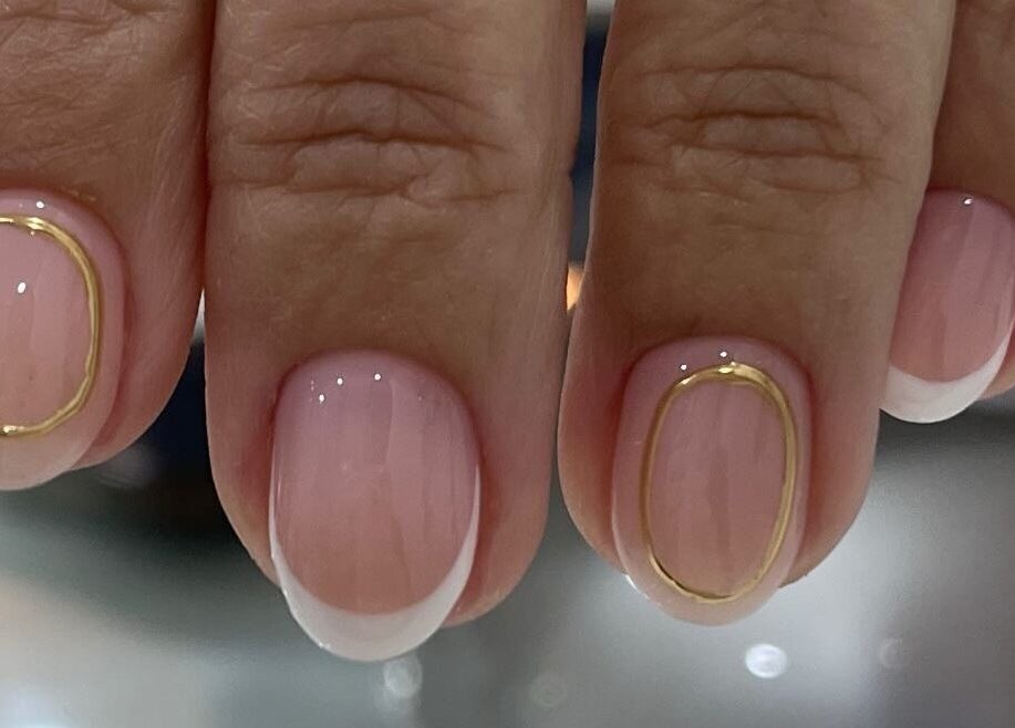 Close-up of a chic nail design at Nailz, Guaynabo, PR featuring pink polish with gold accents.
