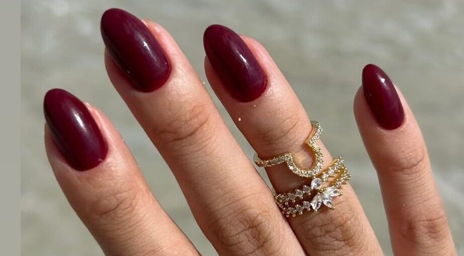 Elegant maroon nails with gold rings at Nailz in Guaynabo, PR, PR offer a stylish look.