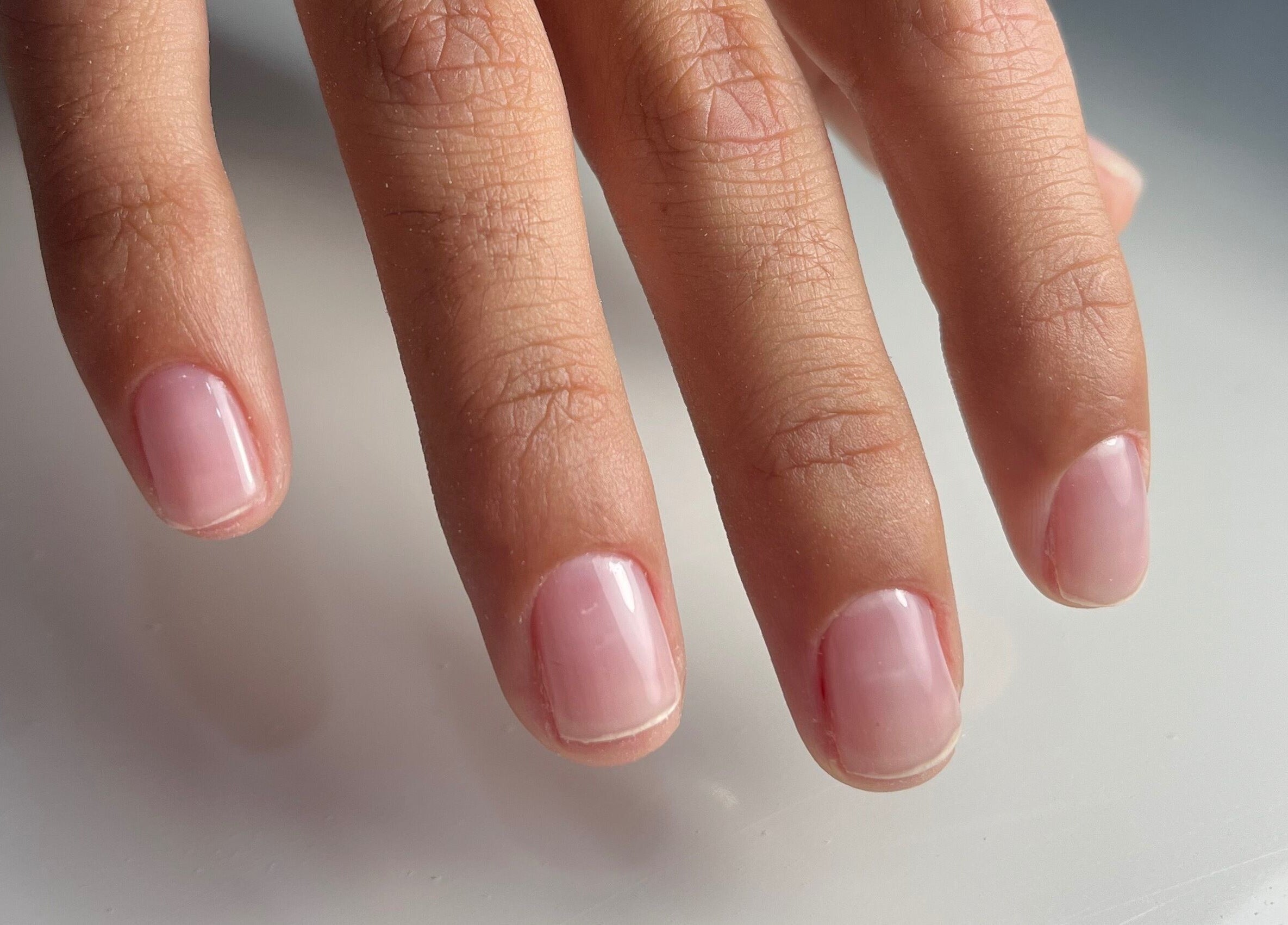 Manicured hand with glossy pink nails at Nailz, Guaynabo, PR, PR, showcasing professional nail care.