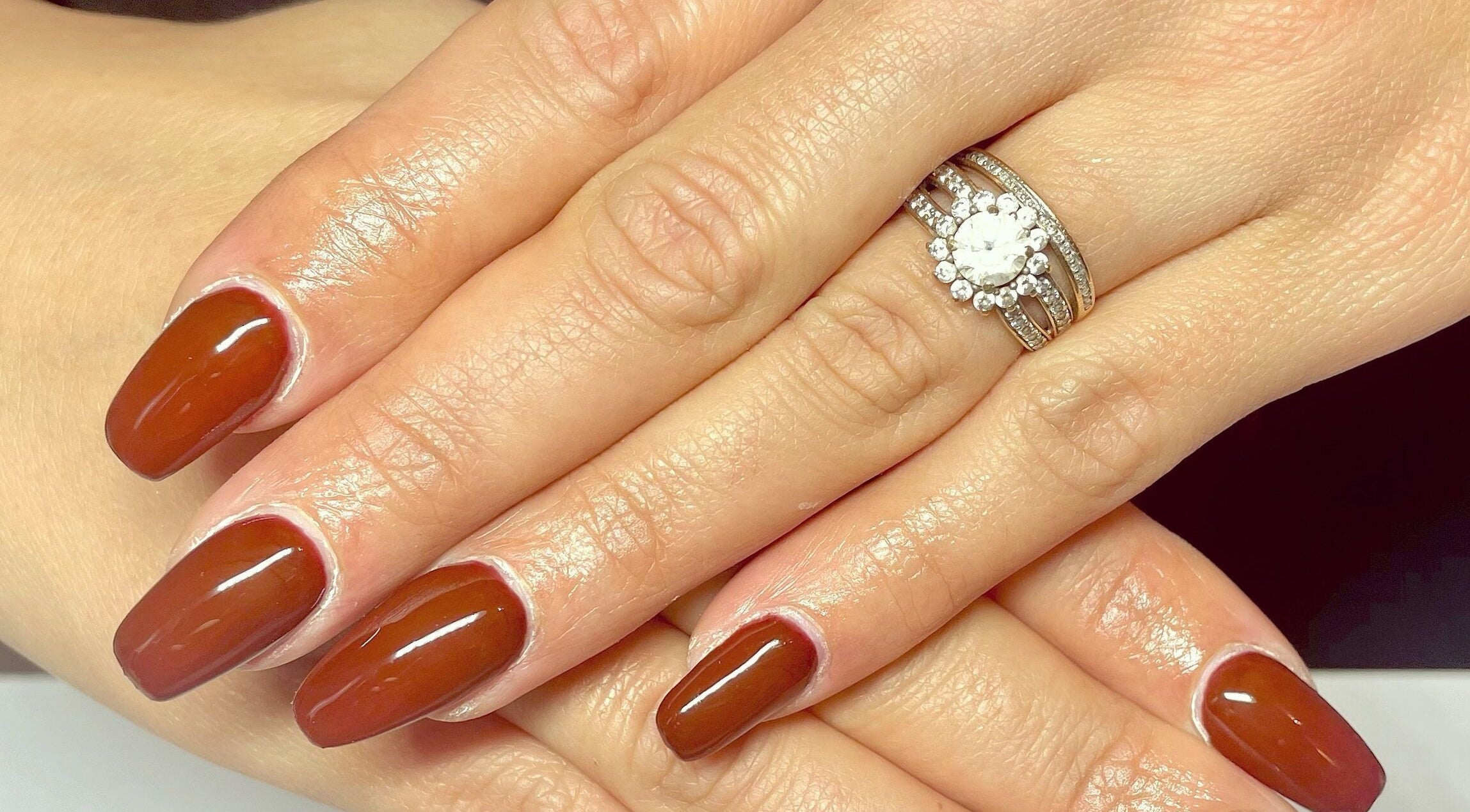 Manucure élégante aux ongles brun à Noddy Nails, Baho, Occitanie, FR, accentuée par une bague scintillante.