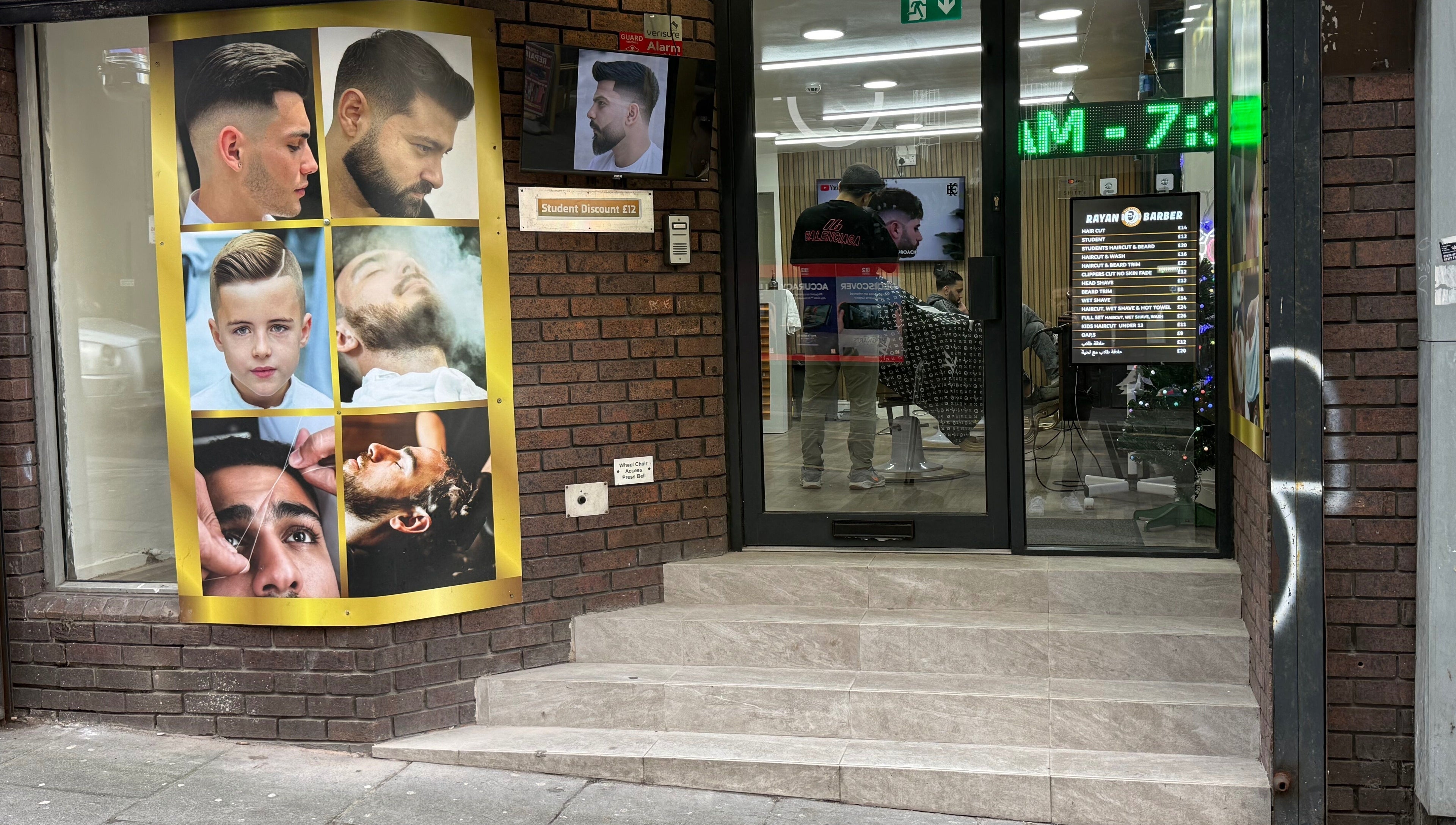 Entrance of Rayan Barber in Liverpool, England, GB with modern hair style posters displayed.