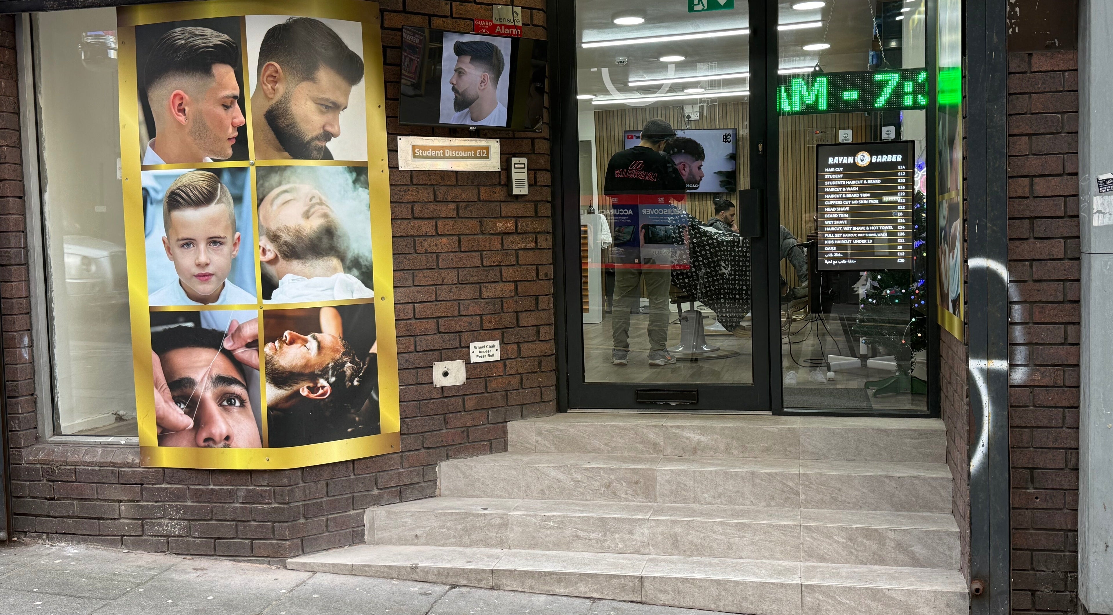 Entrance of Rayan Barber in Liverpool, England, GB with modern hair style posters displayed.