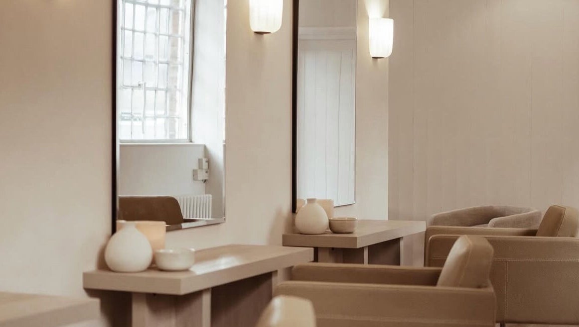 Elegant salon interior at Facemuse, Derby, England, GB showcasing chic beige seating and stylish mirrors.