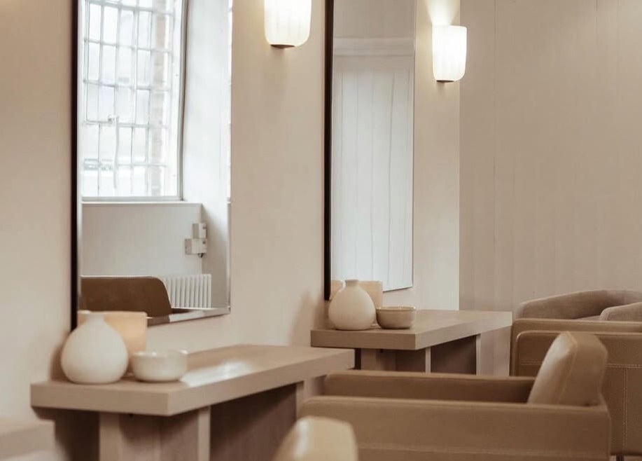 Elegant salon interior at Facemuse, Derby, England, GB showcasing chic beige seating and stylish mirrors.