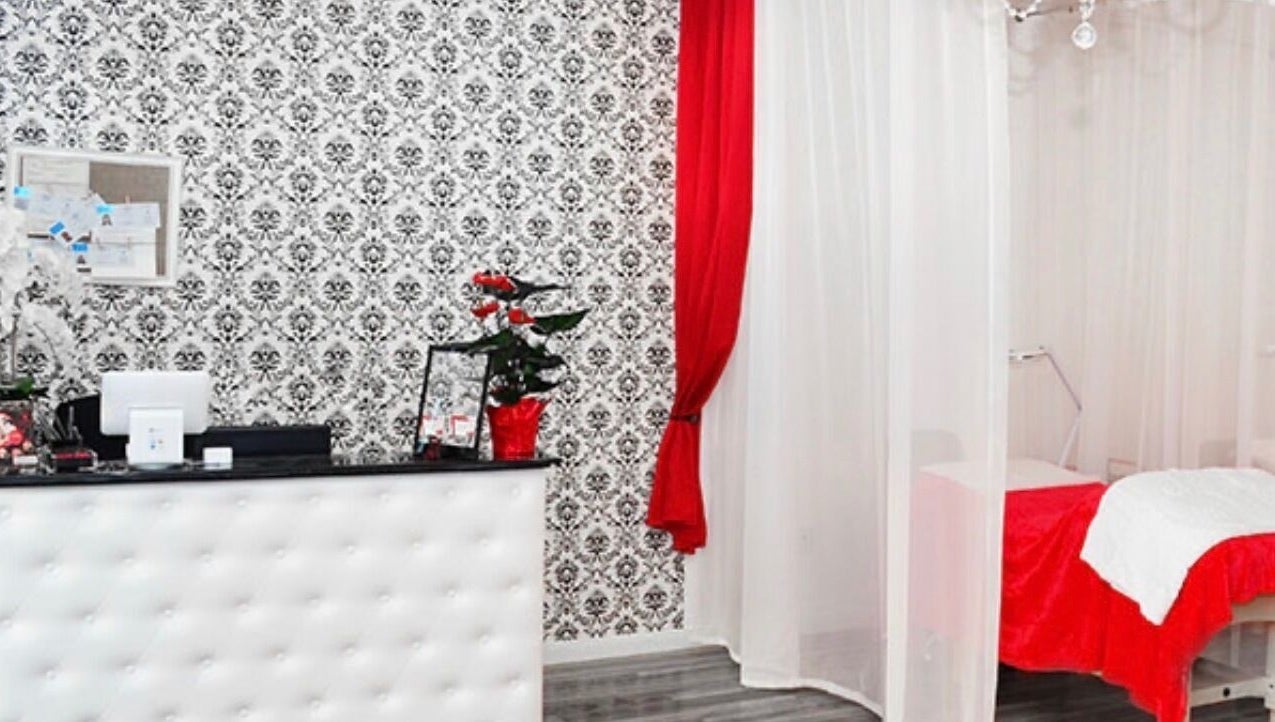 Chic interior of LashesByYuna in Henderson, Nevada, US, with ornate black and white wallpaper and red accents.