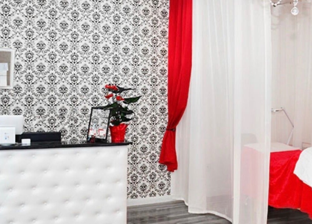 Chic interior of LashesByYuna in Henderson, Nevada, US, with ornate black and white wallpaper and red accents.