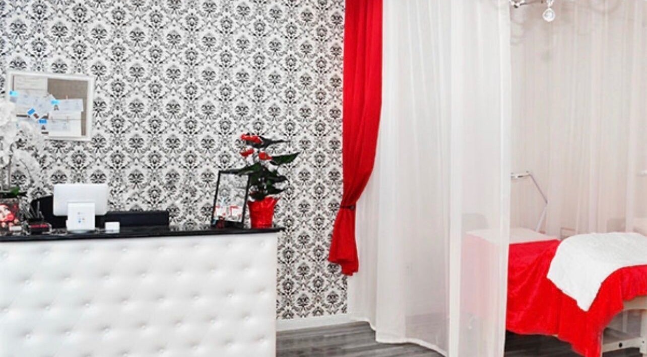 Chic interior of LashesByYuna in Henderson, Nevada, US, with ornate black and white wallpaper and red accents.