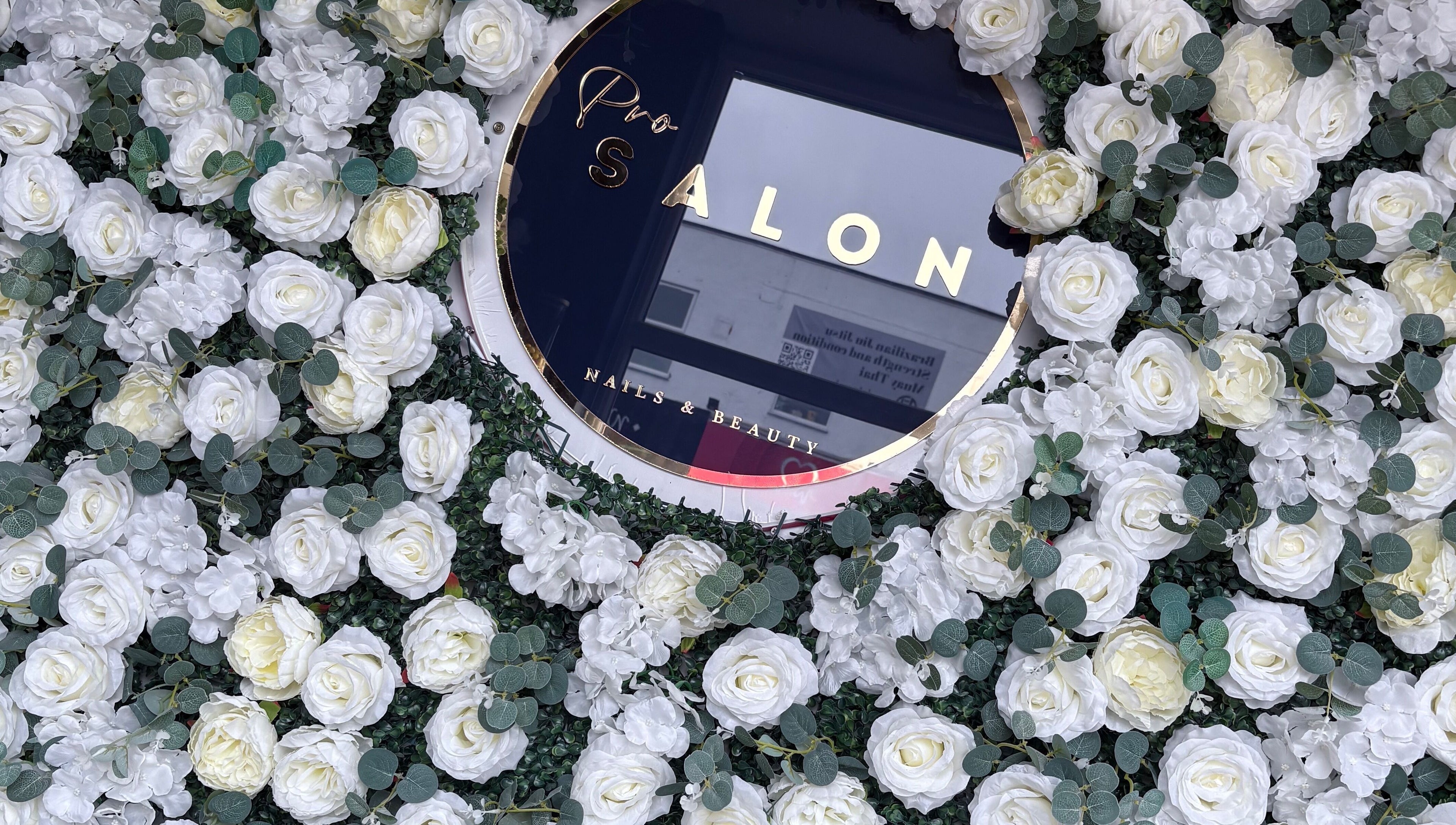 A lush floral wall with a sign of probeauty.paige, Poole, England, GB, showcasing elegance and style.