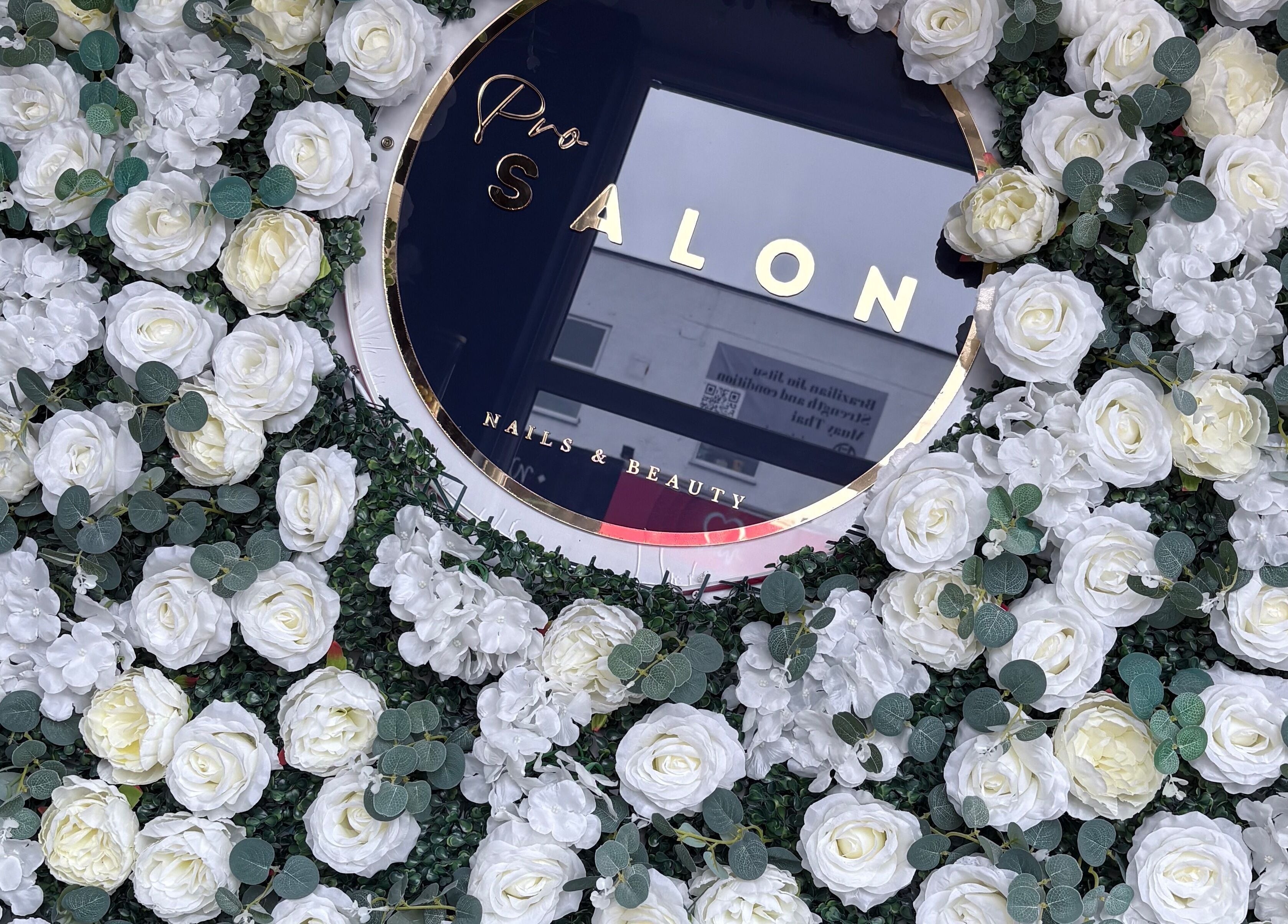 A lush floral wall with a sign of probeauty.paige, Poole, England, GB, showcasing elegance and style.
