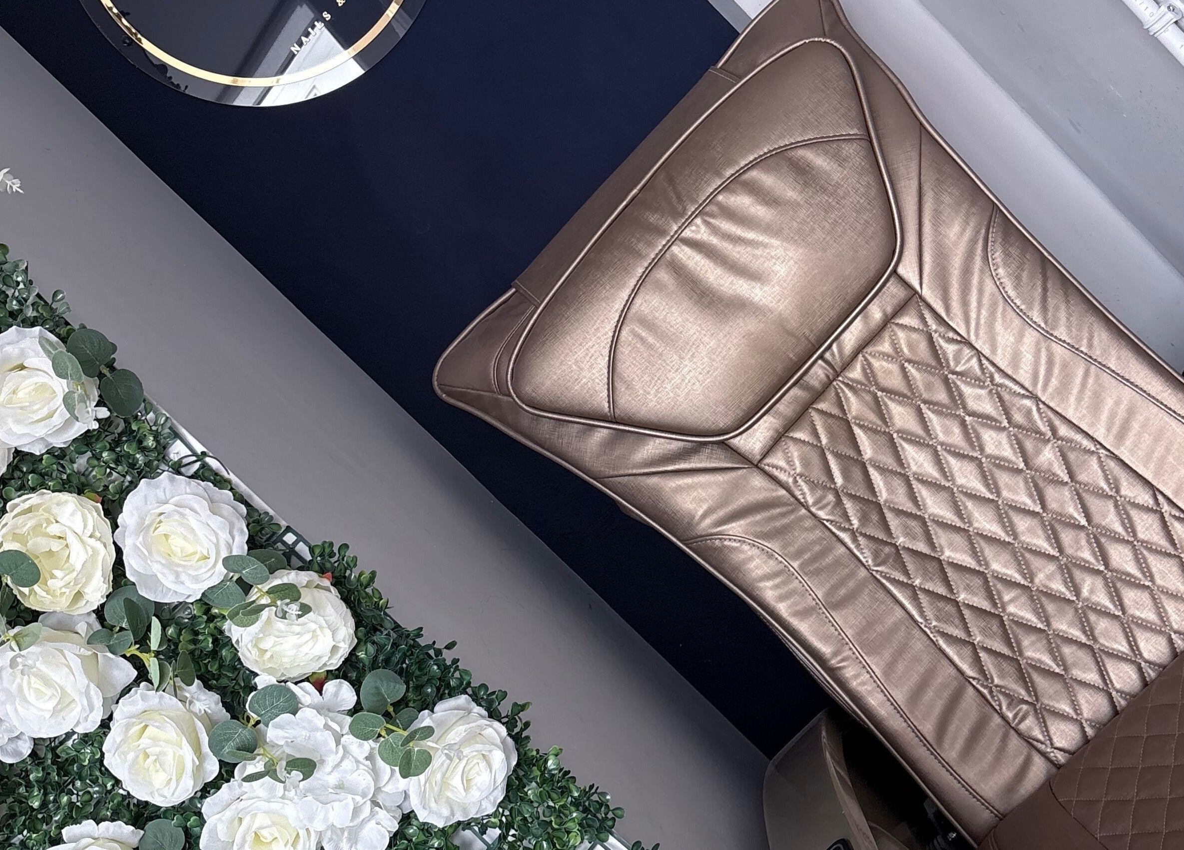 Elegant leather chair at Probeauty.Paige, Poole, England, GB surrounded by white flowers for relaxation.