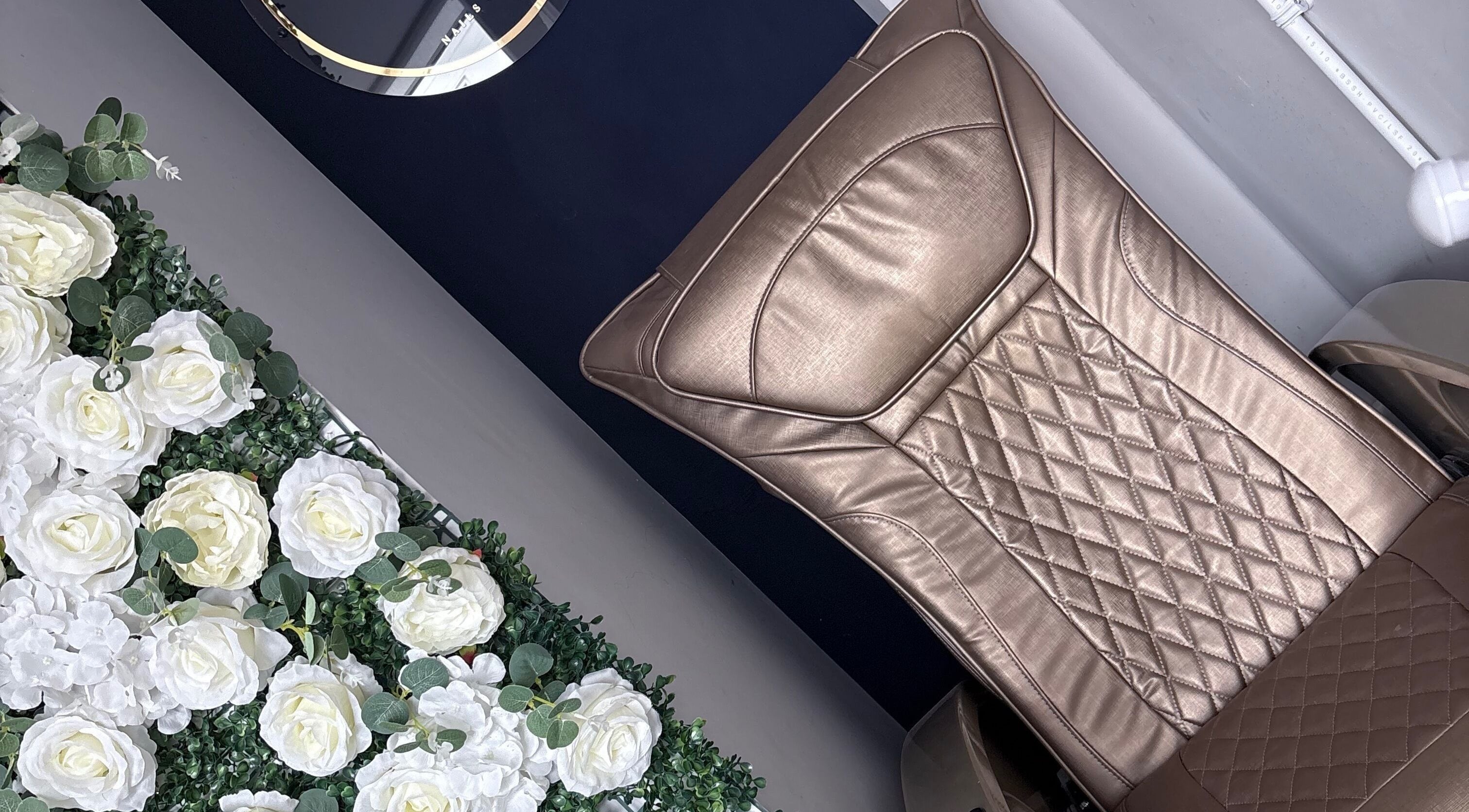 Elegant leather chair at Probeauty.Paige, Poole, England, GB surrounded by white flowers for relaxation.