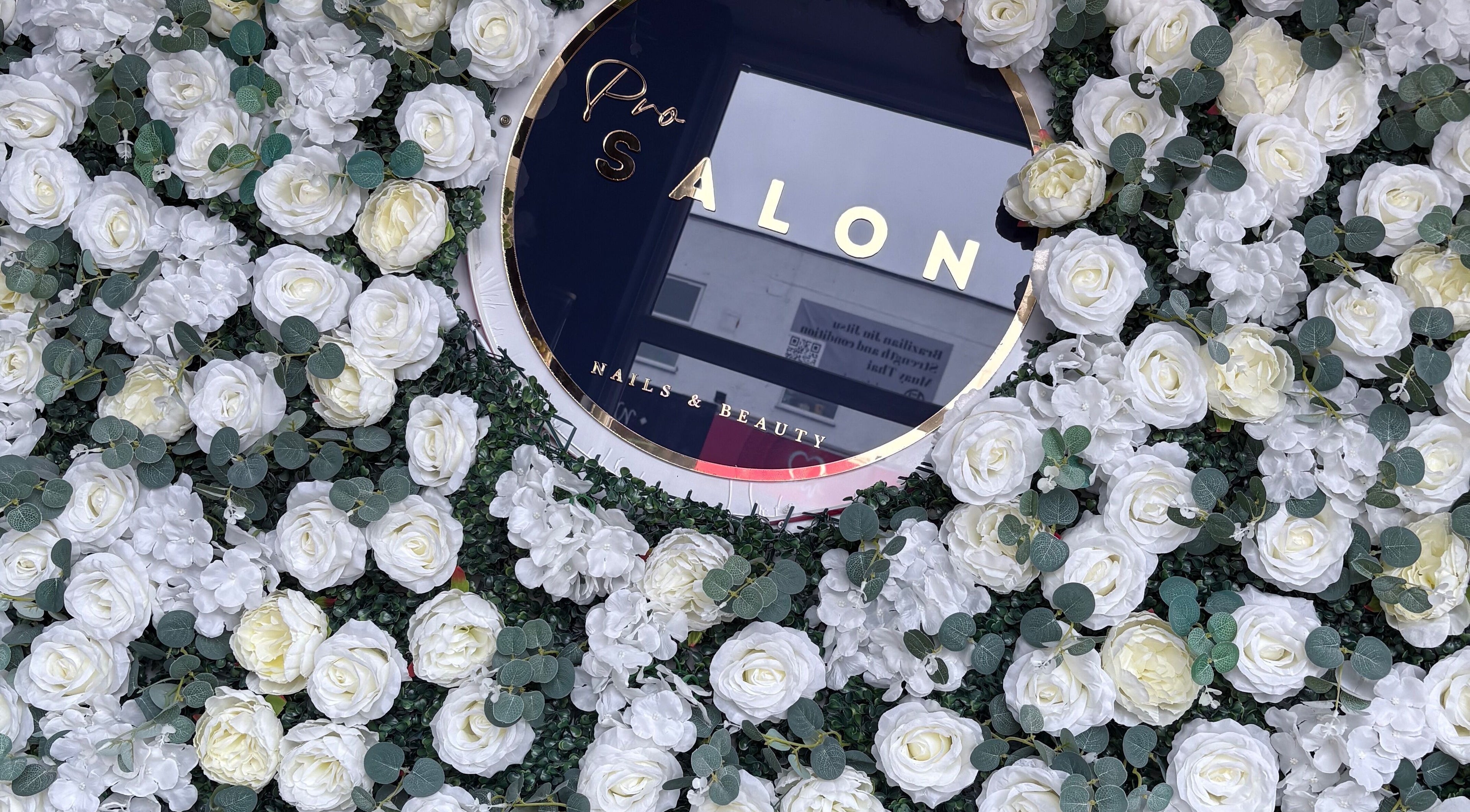 Entrance to Probeauty.Paige in Poole, England, GB adorned with white roses and a chic salon sign.