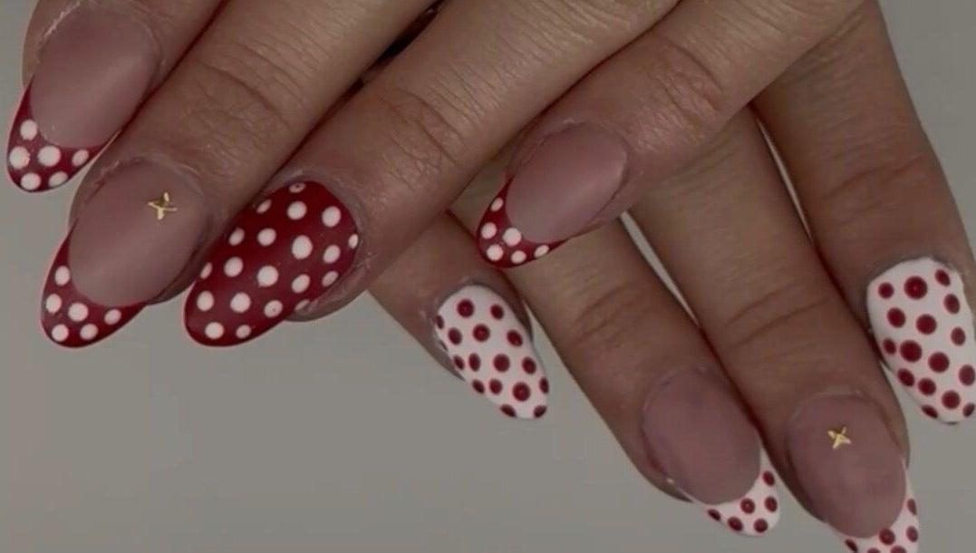Red and white polka dot nails at Nails by Ela in Blainville, Québec, CA. Trendy and stylish nail art design.