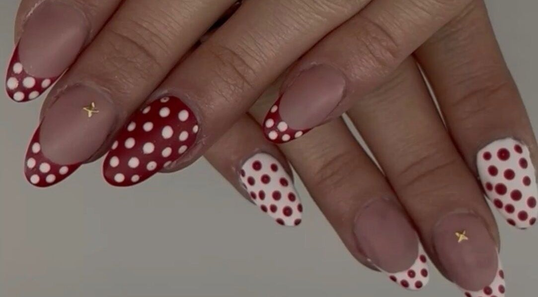 Red and white polka dot nails at Nails by Ela in Blainville, Québec, CA. Trendy and stylish nail art design.