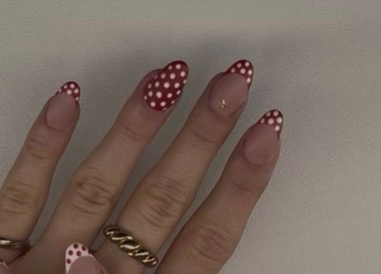 Stylish red polka dot nail art by Nails by Ela in Blainville, Québec, CA, showcasing intricate hand design.