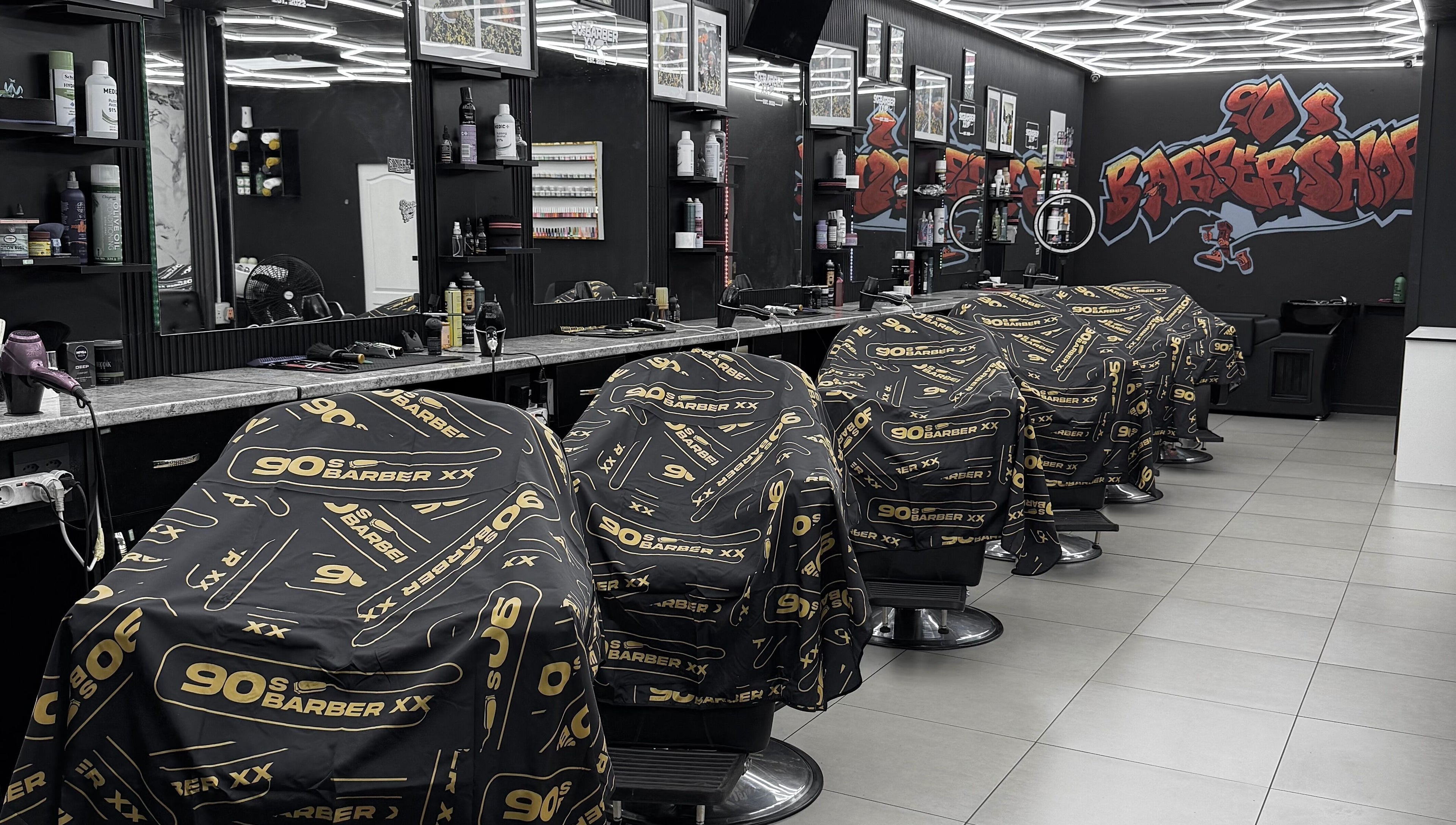 Interior view of 90s barberxx shop in Middelburg, Mpumalanga, ZA with sleek black and gold decor.
