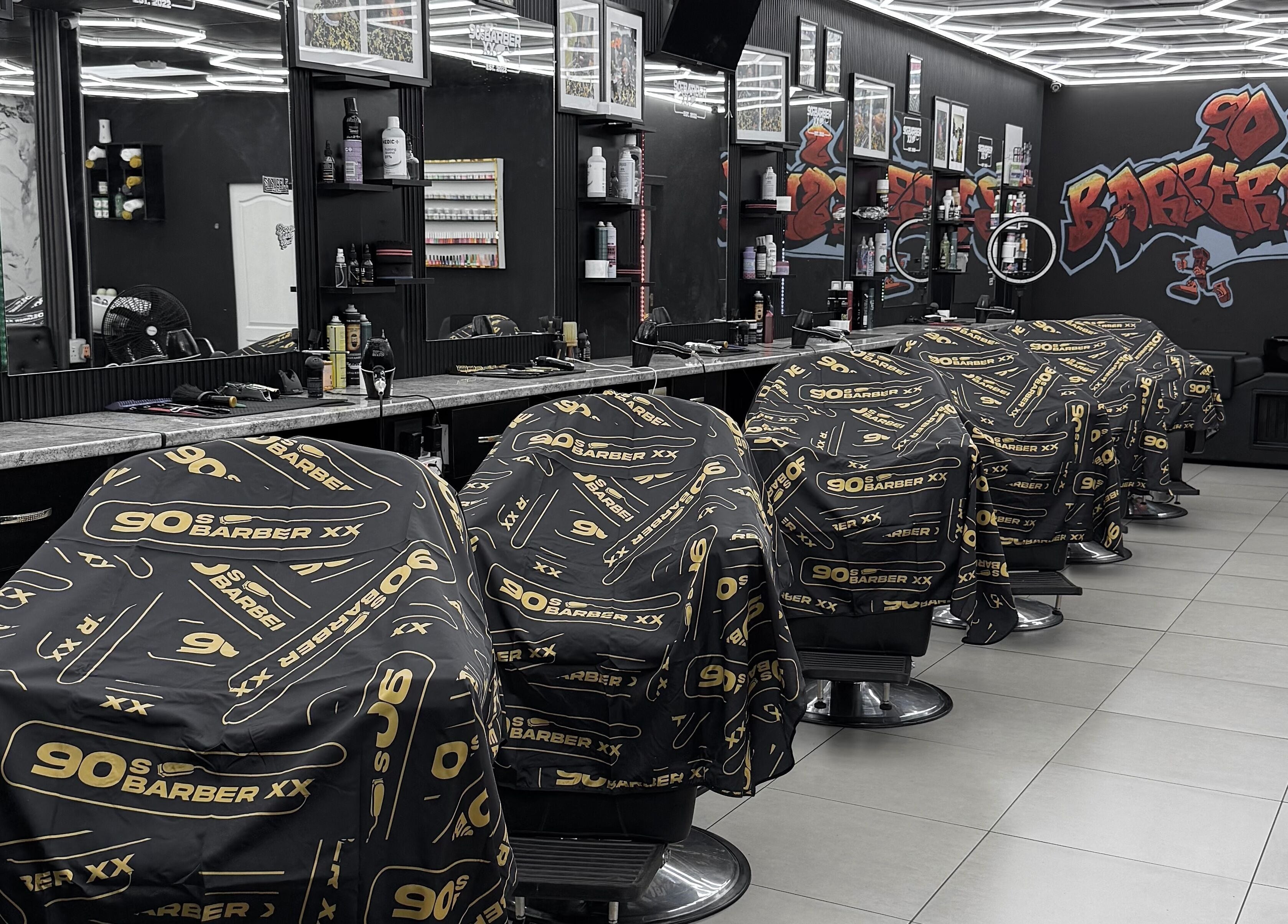 Interior view of 90s barberxx shop in Middelburg, Mpumalanga, ZA with sleek black and gold decor.