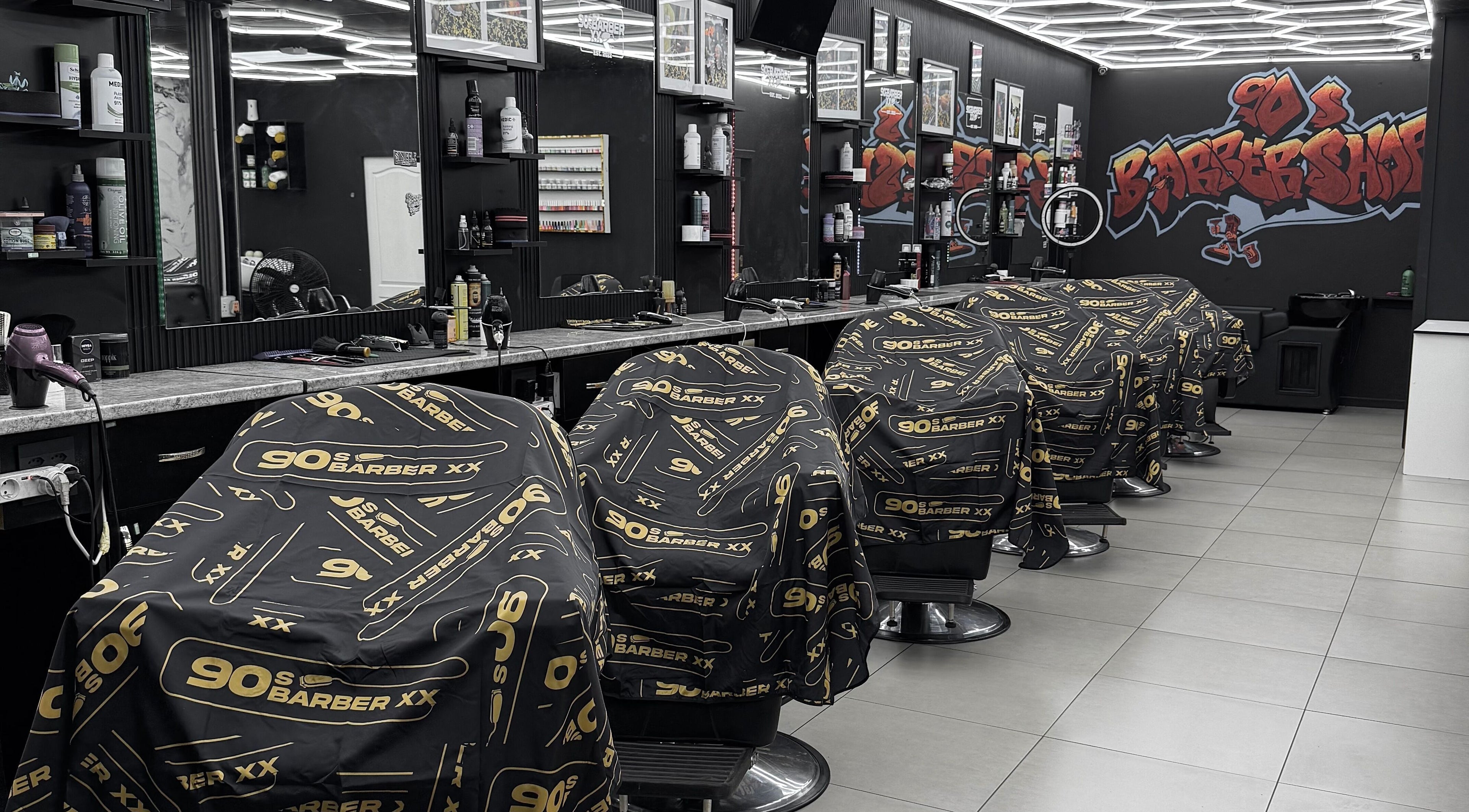 Interior view of 90s barberxx shop in Middelburg, Mpumalanga, ZA with sleek black and gold decor.