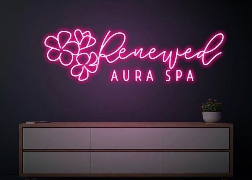 Vibrant neon sign of RAS at Gainesville, Virginia, US, glowing in pink above a minimalist white cabinet.