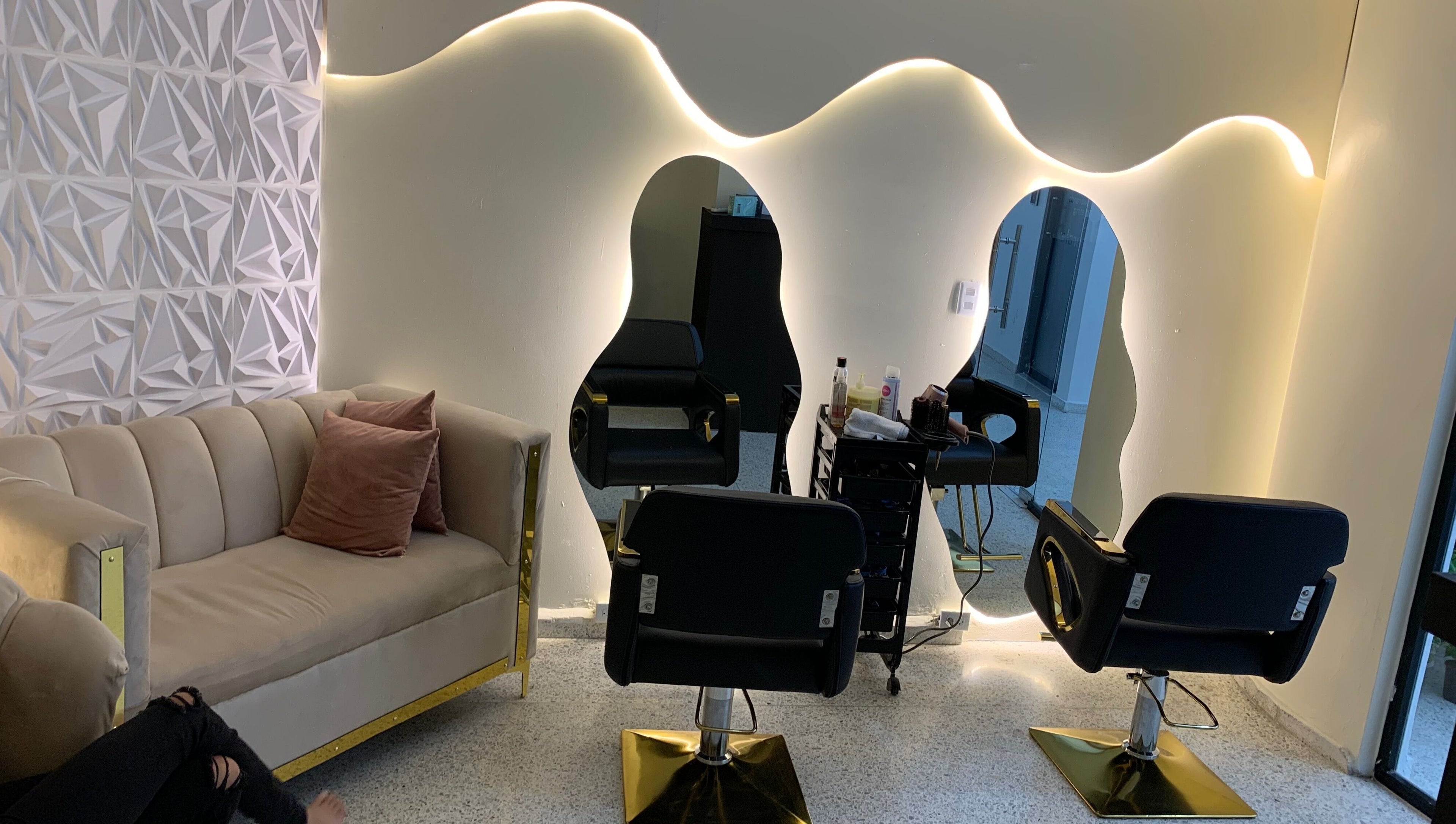 Modern chic interior of LP Hair Salon in Santiago De Los Caballeros. Stylish seating and lit mirrors create a welcoming vibe.