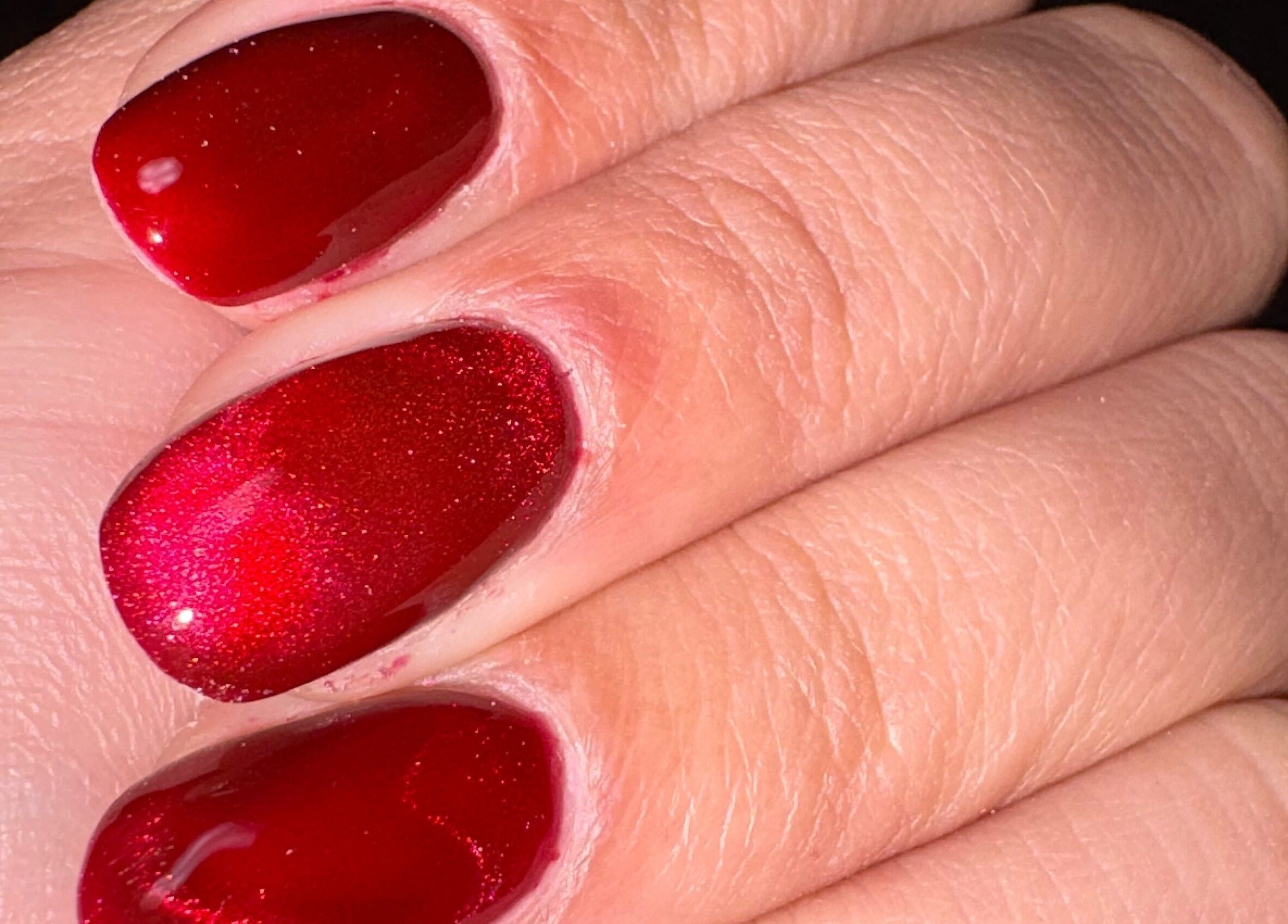 Close-up of glossy red nails at Kei Luxe Nails, Oxford, Massachusetts, US, showcasing expert manicure art.