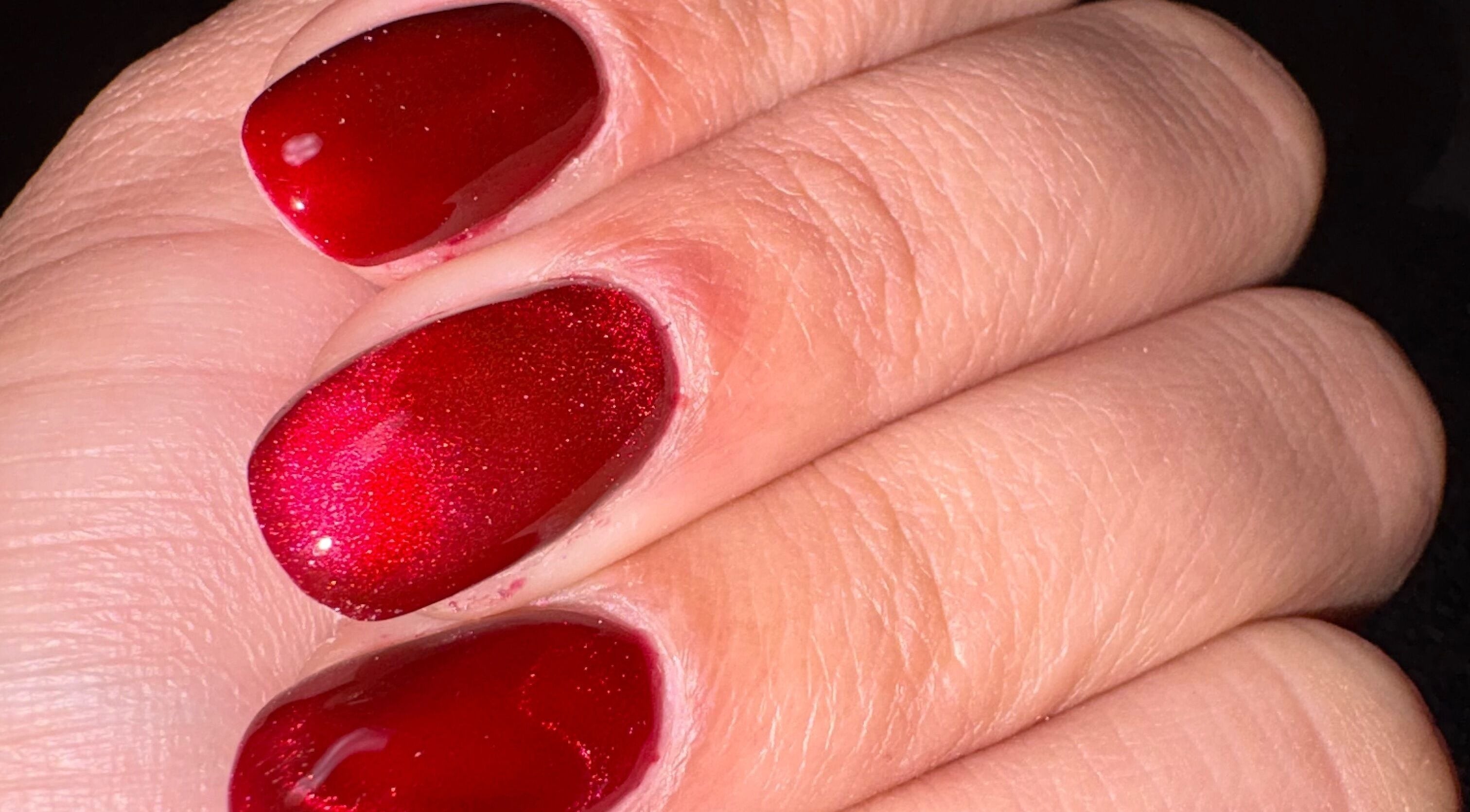 Close-up of glossy red nails at Kei Luxe Nails, Oxford, Massachusetts, US, showcasing expert manicure art.