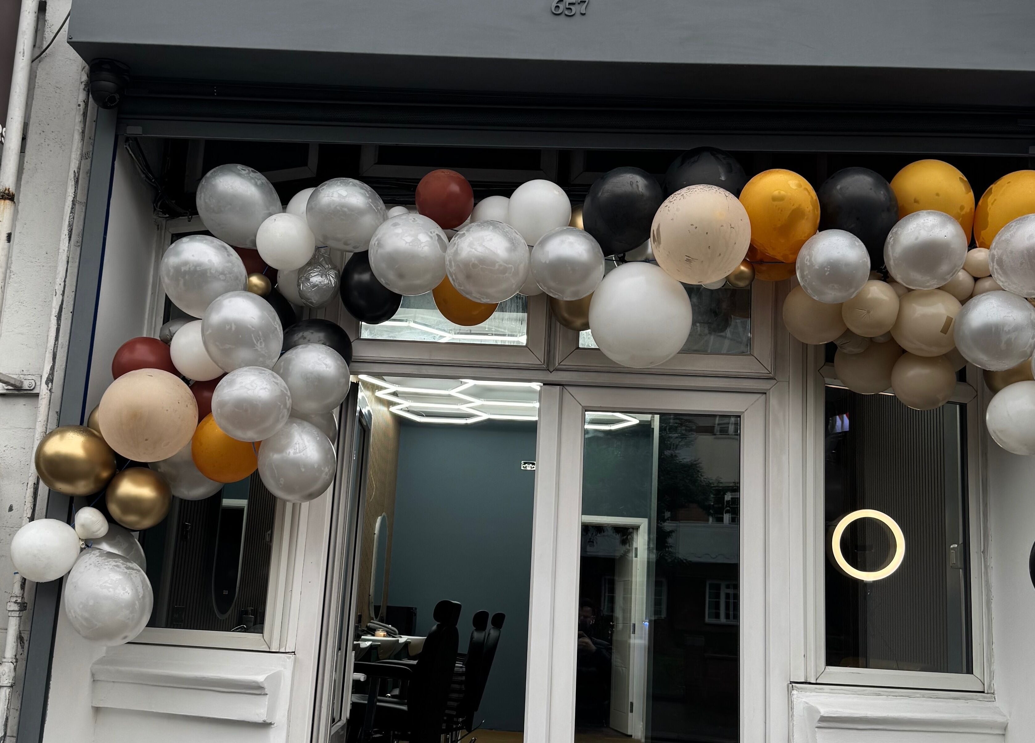 Elegant balloon arch at STEEL BARBERS entrance, London, England, GB.