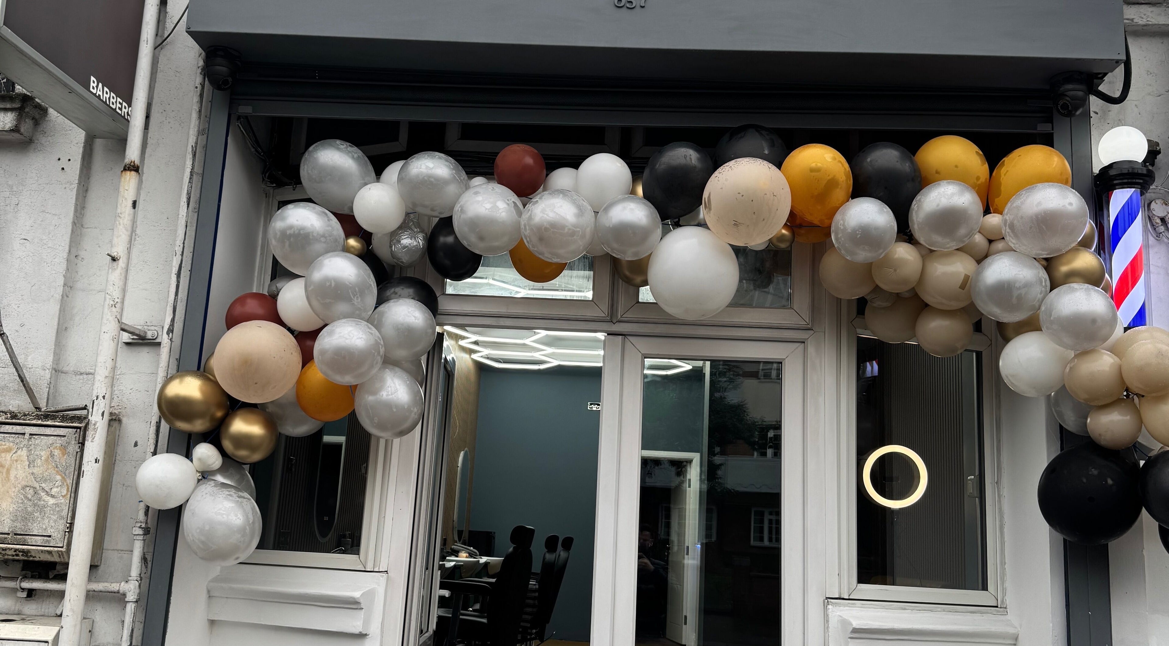 Elegant balloon arch at STEEL BARBERS entrance, London, England, GB.