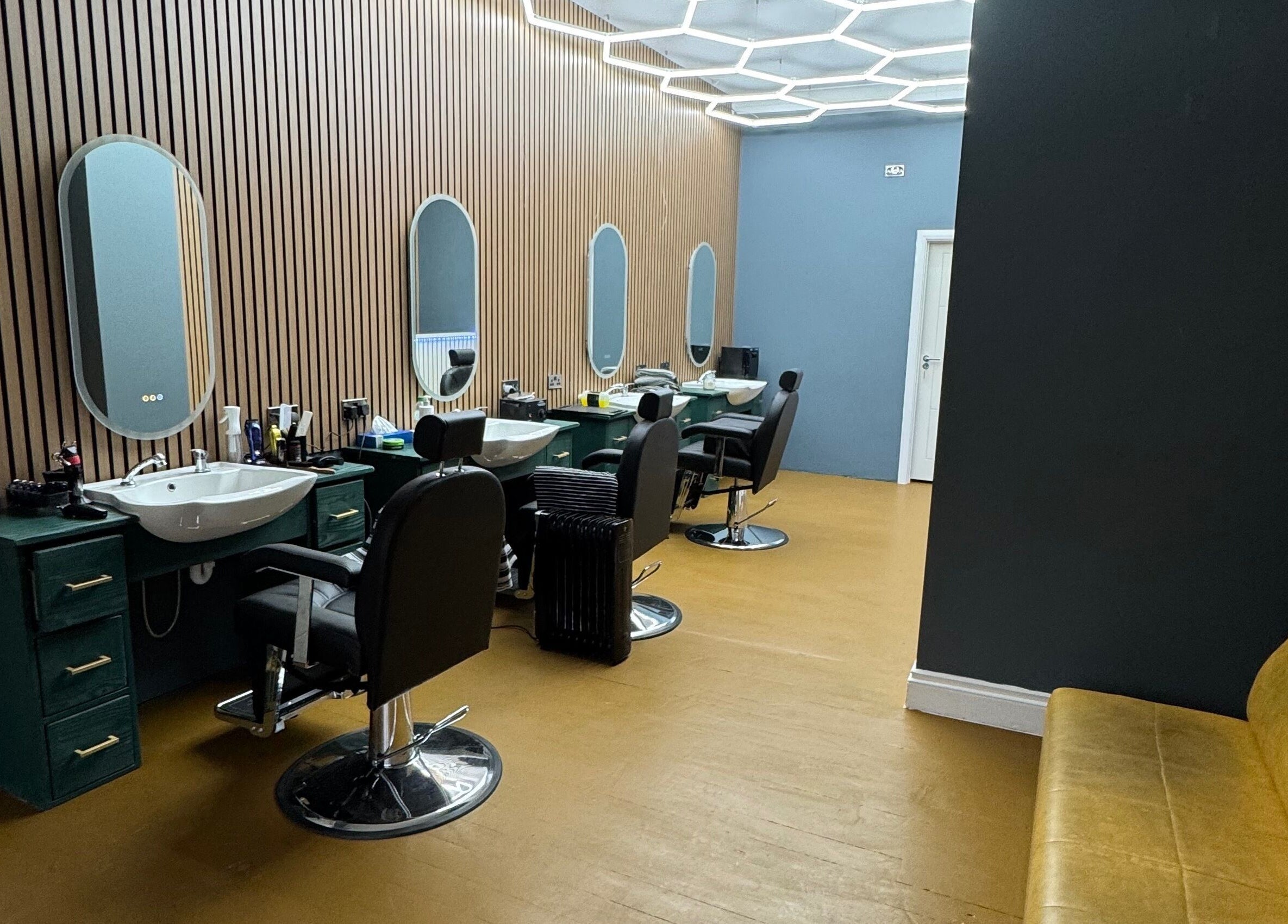 Interior of STEEL BARBERS in London, England, GB, featuring sleek chairs and stylish mirrors.