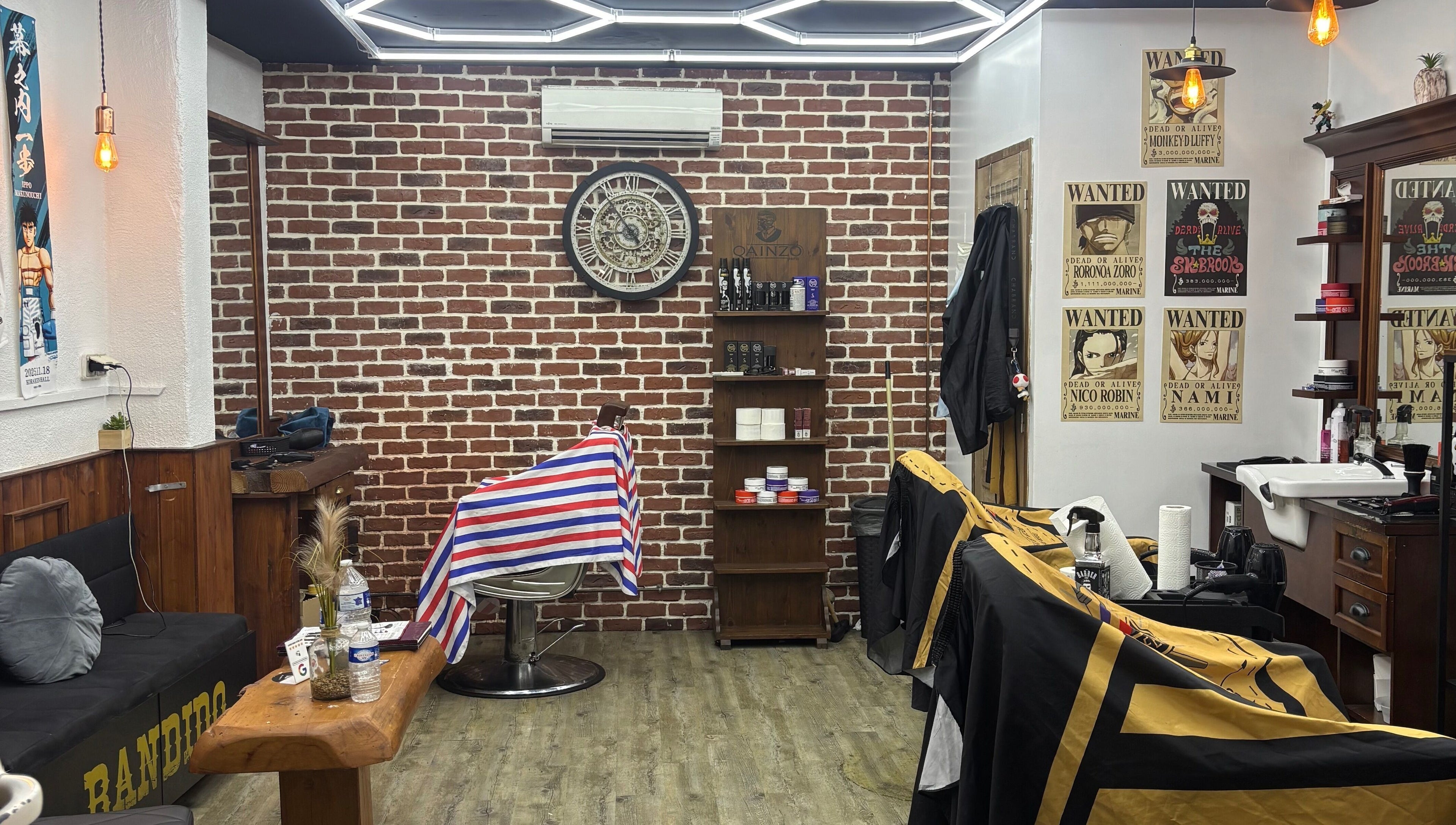 Salon rétro chez Barber Style 25 à Orange, Provence-Alpes-Côte d'Azur. Décor en briques et fauteuils.