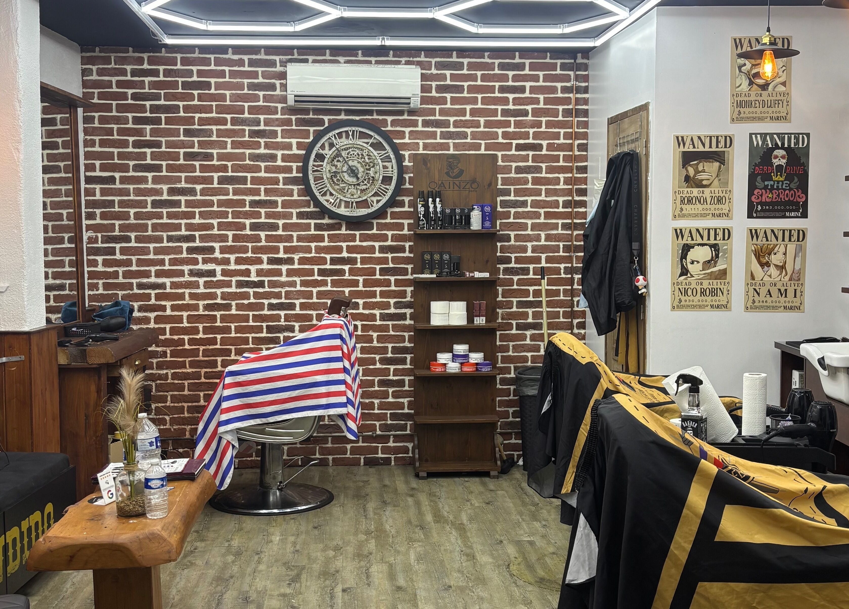 Salon rétro chez Barber Style 25 à Orange, Provence-Alpes-Côte d'Azur. Décor en briques et fauteuils.