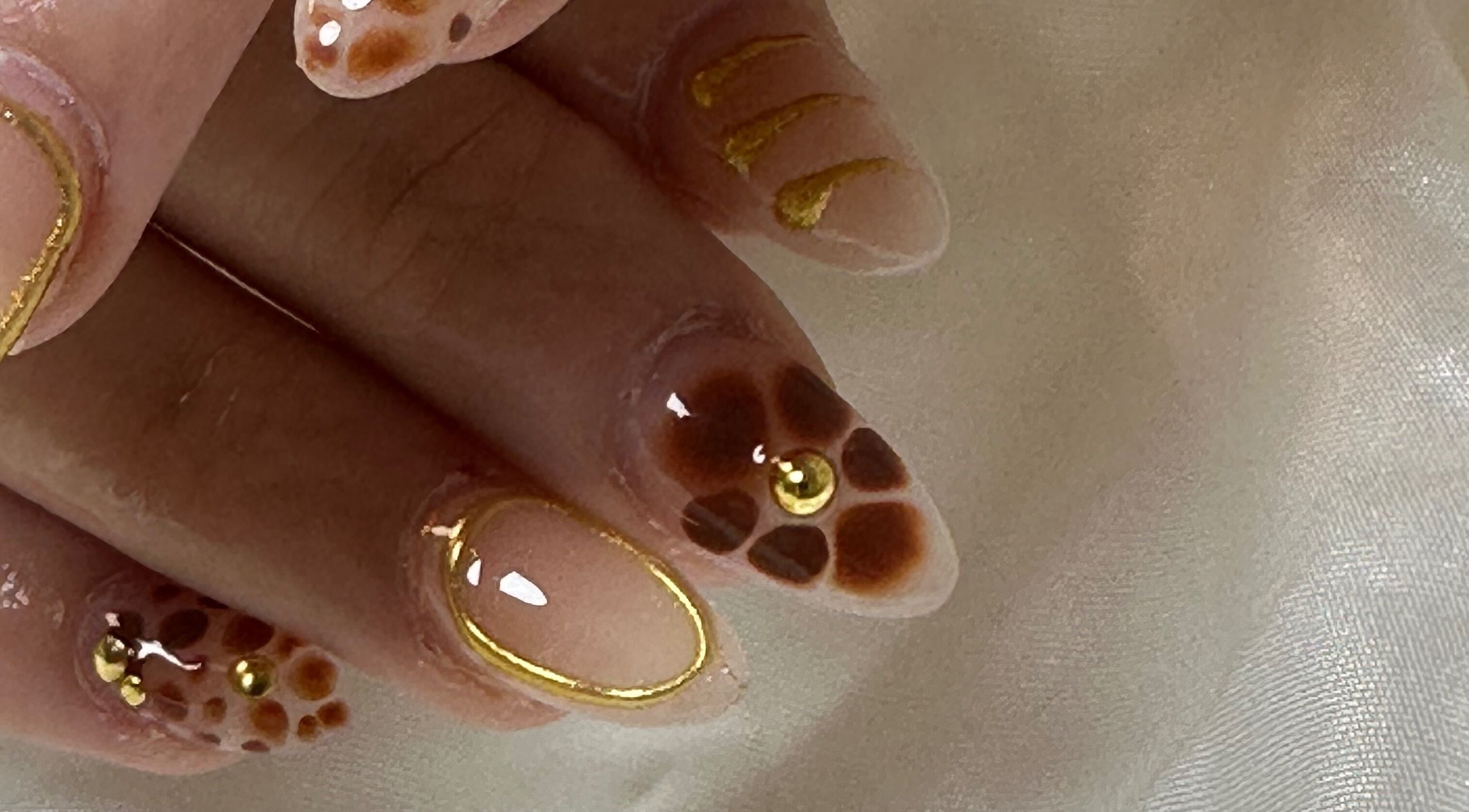 Manucure ornée d'or à Les déesses Institut, Épretot, Normandie, FR.