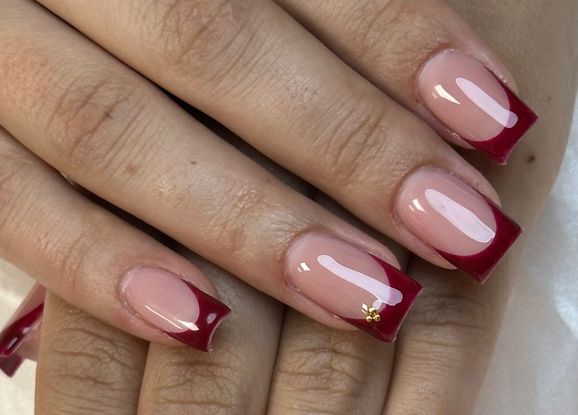 Manucure élégante chez Les déesses Institut à Épretot, Normandie, FR. Ongles rouges brillants.