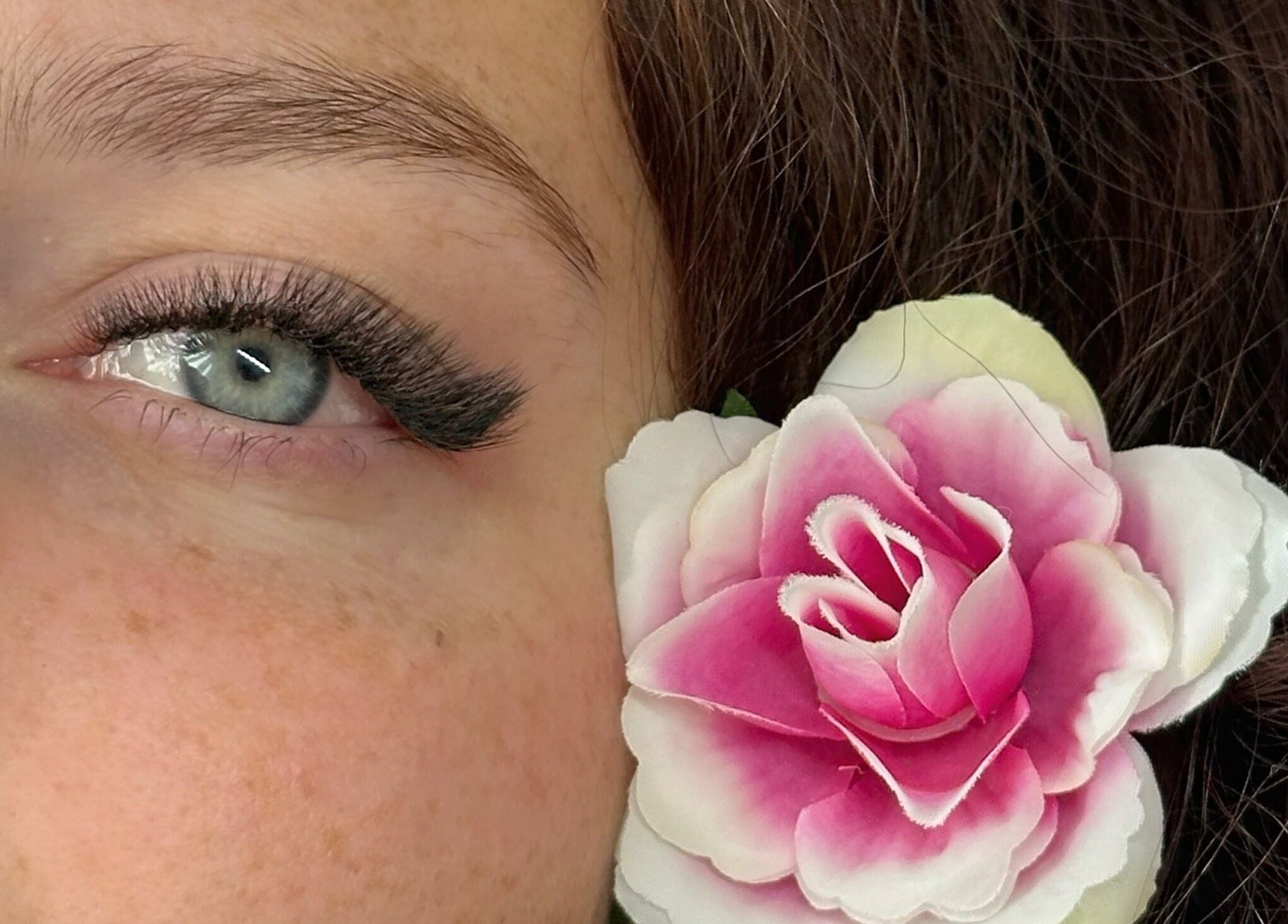 Grossissement d'un œil avec fleur rose chez Les déesses Institut, Épretot, Normandie, FR.