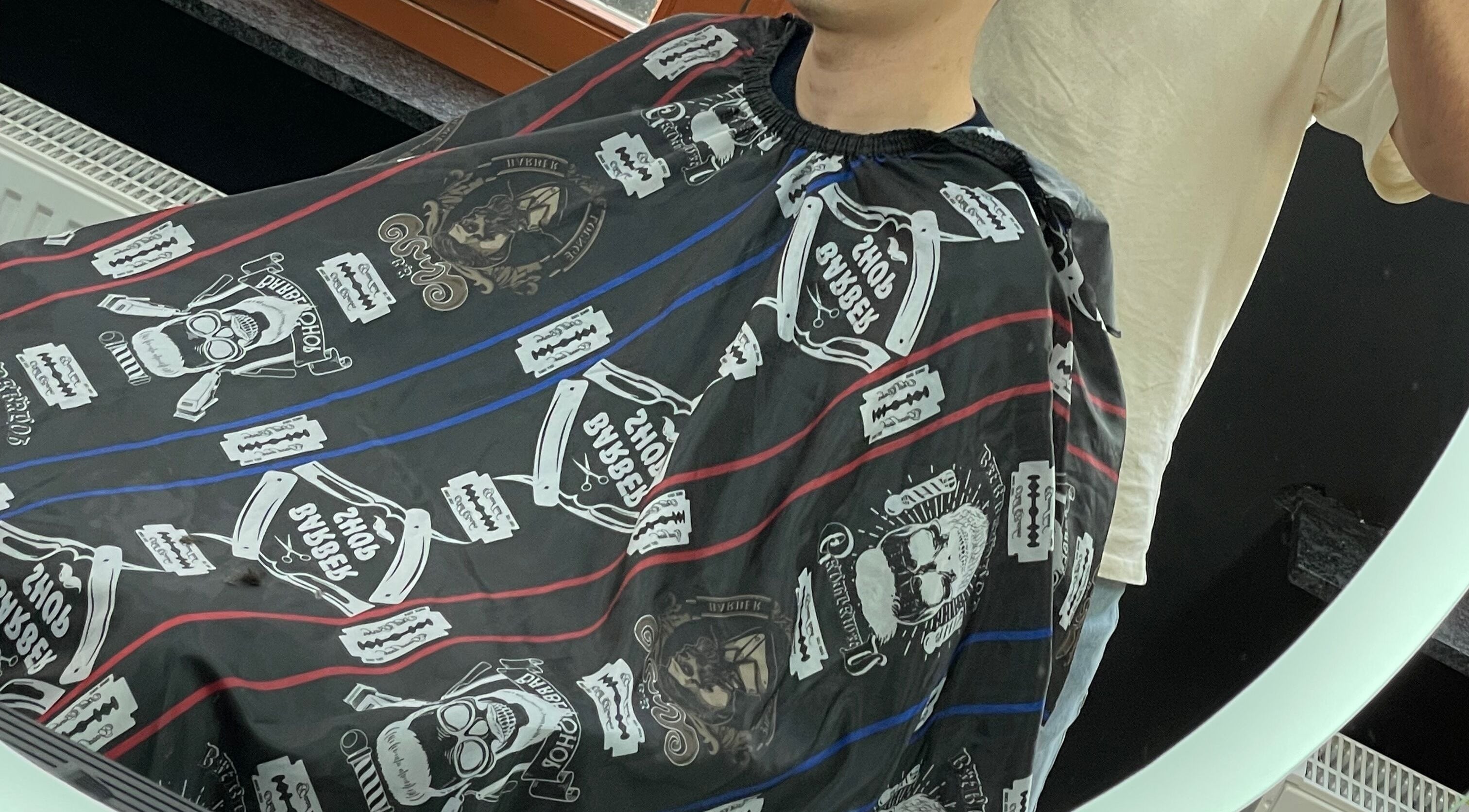 Stylish haircut setup at Fade Culture Barbershop in Mosta, MT, featuring unique barber cape designs.