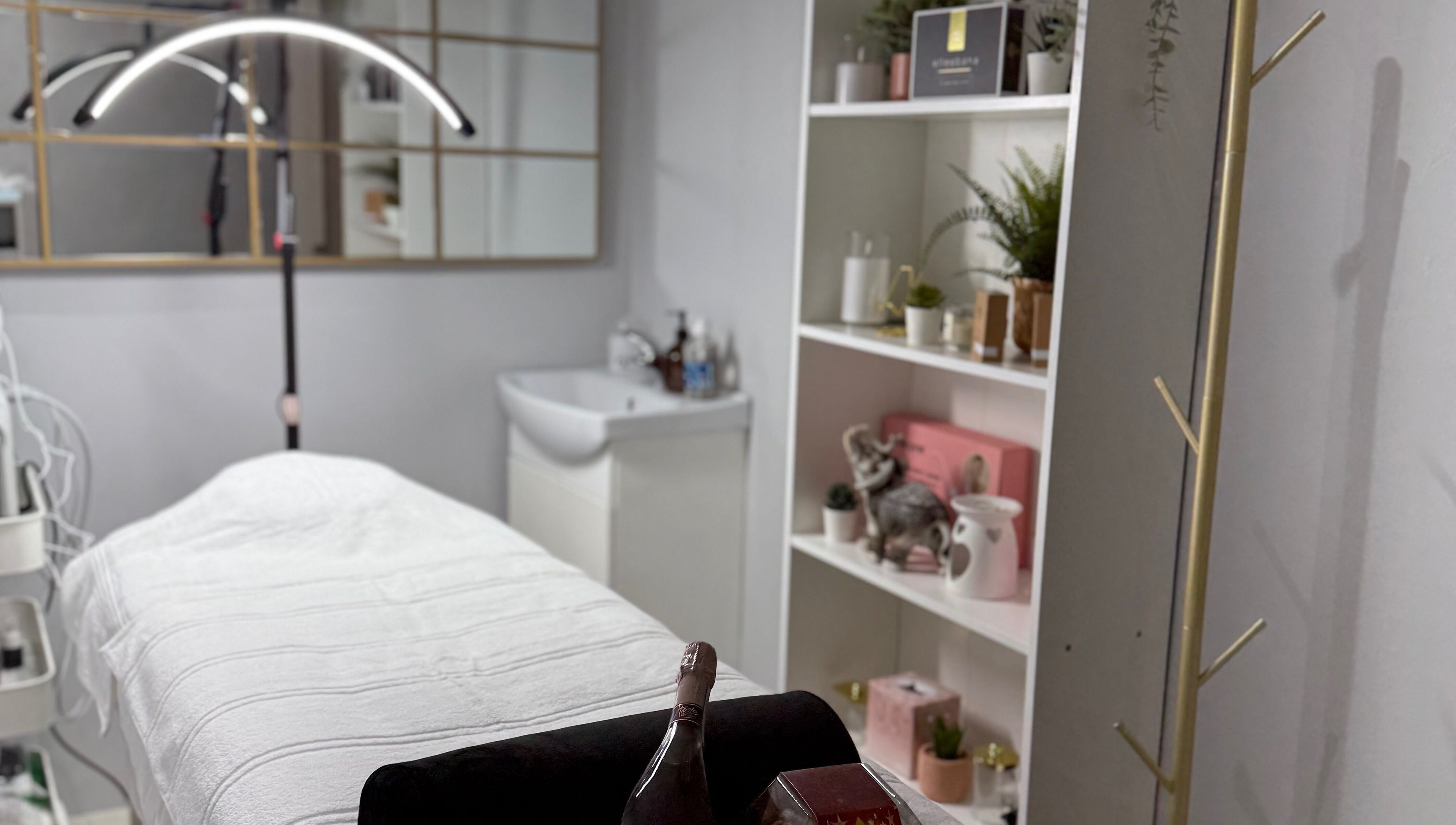 Relaxing treatment room at SkinSociety, Sutton, England, GB, featuring a cozy bed and serene decor.