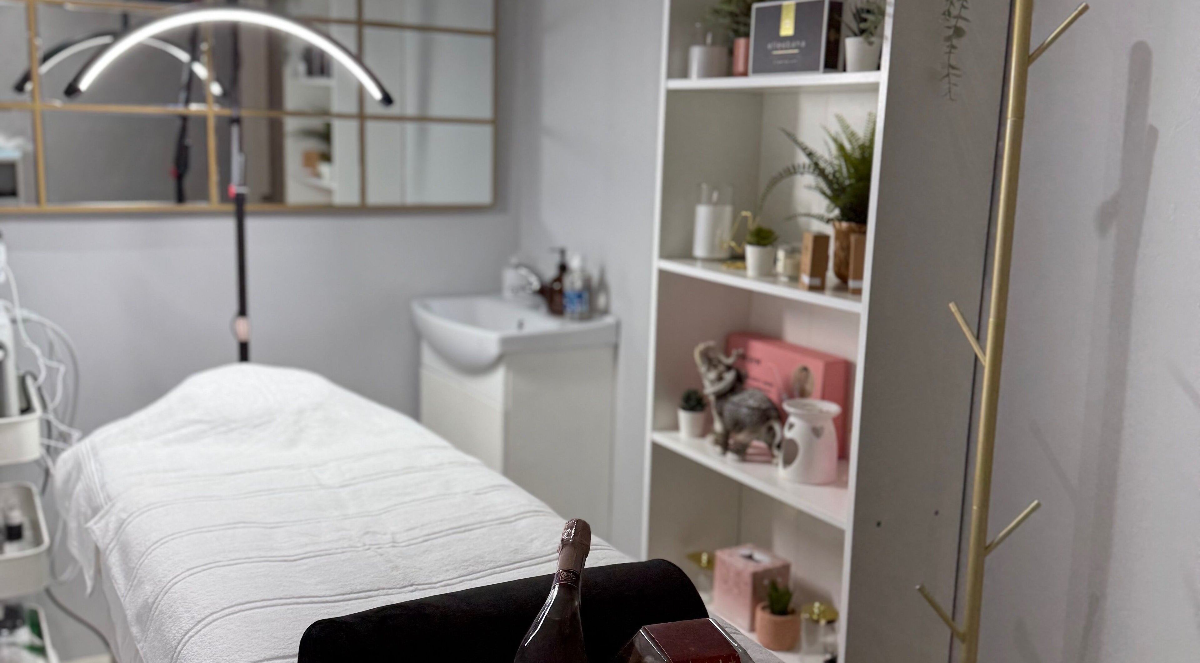 Relaxing treatment room at SkinSociety, Sutton, England, GB, featuring a cozy bed and serene decor.