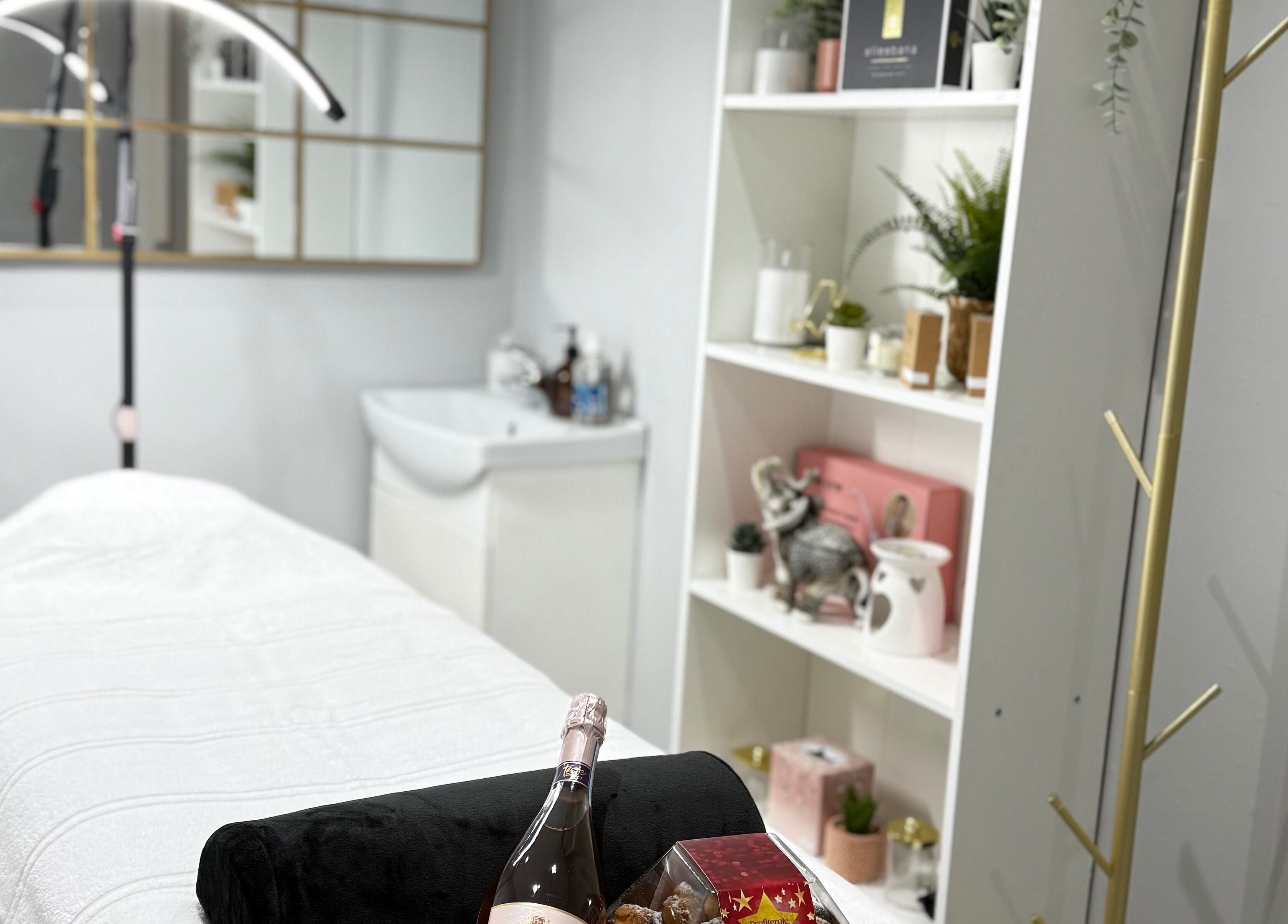 Cozy treatment room at SkinSociety in Sutton, England showcasing a massage table and elegant decor.