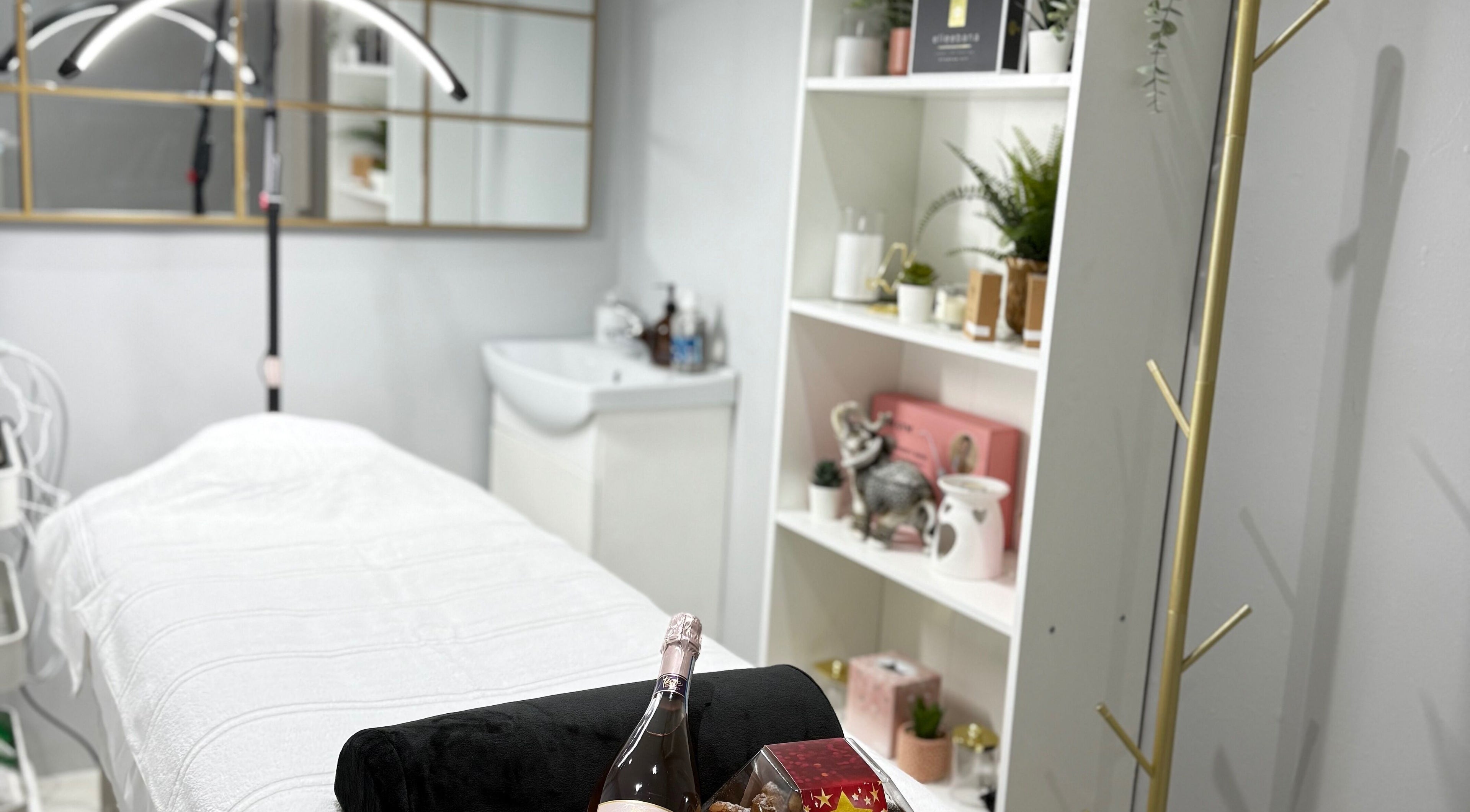 Cozy treatment room at SkinSociety in Sutton, England showcasing a massage table and elegant decor.