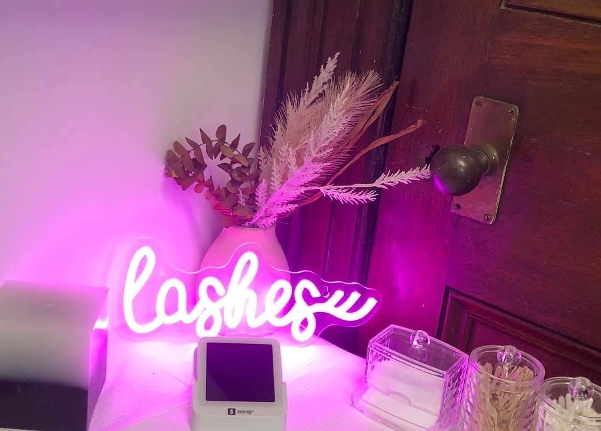 Prettylittle beauty's vibrant lash display with neon sign in Pembroke, Wales, GB enhancing ambiance.
