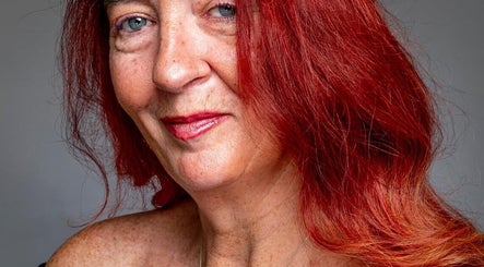 A confident woman at Healing Hands, Weston-super-Mare, England, GB, showcasing vibrant red hair.