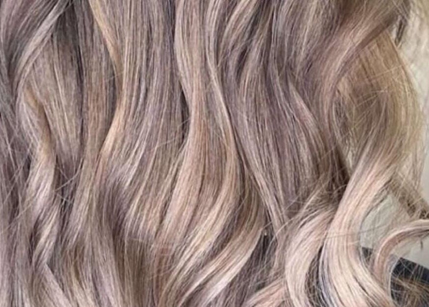 Elegant blonde wavy hair styled at Enhance Studio, Leeds, England, GB. Perfect for a glamorous look.